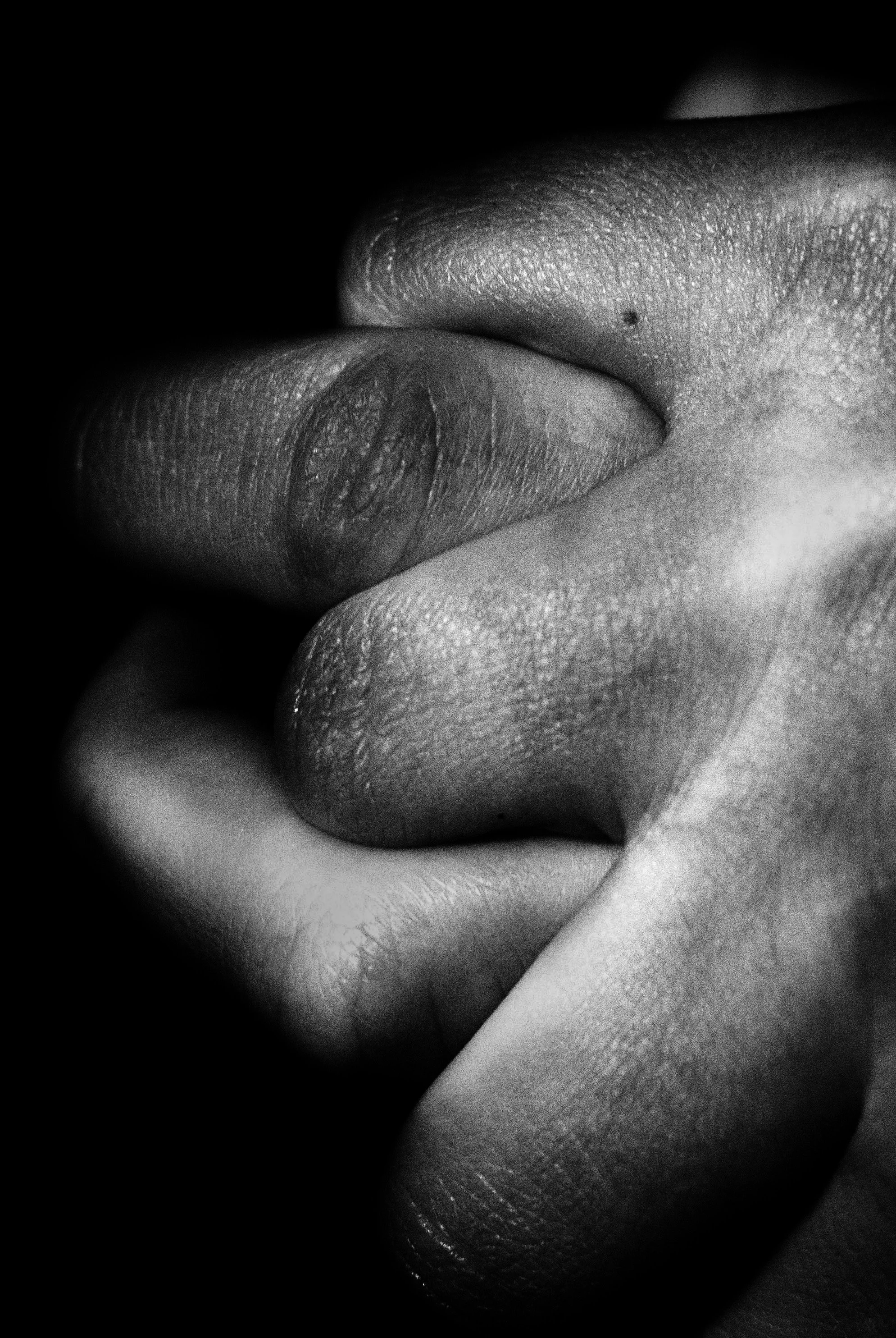 Close-up black and white photograph of a person's finger, focusing on the textured skin and a small mole.