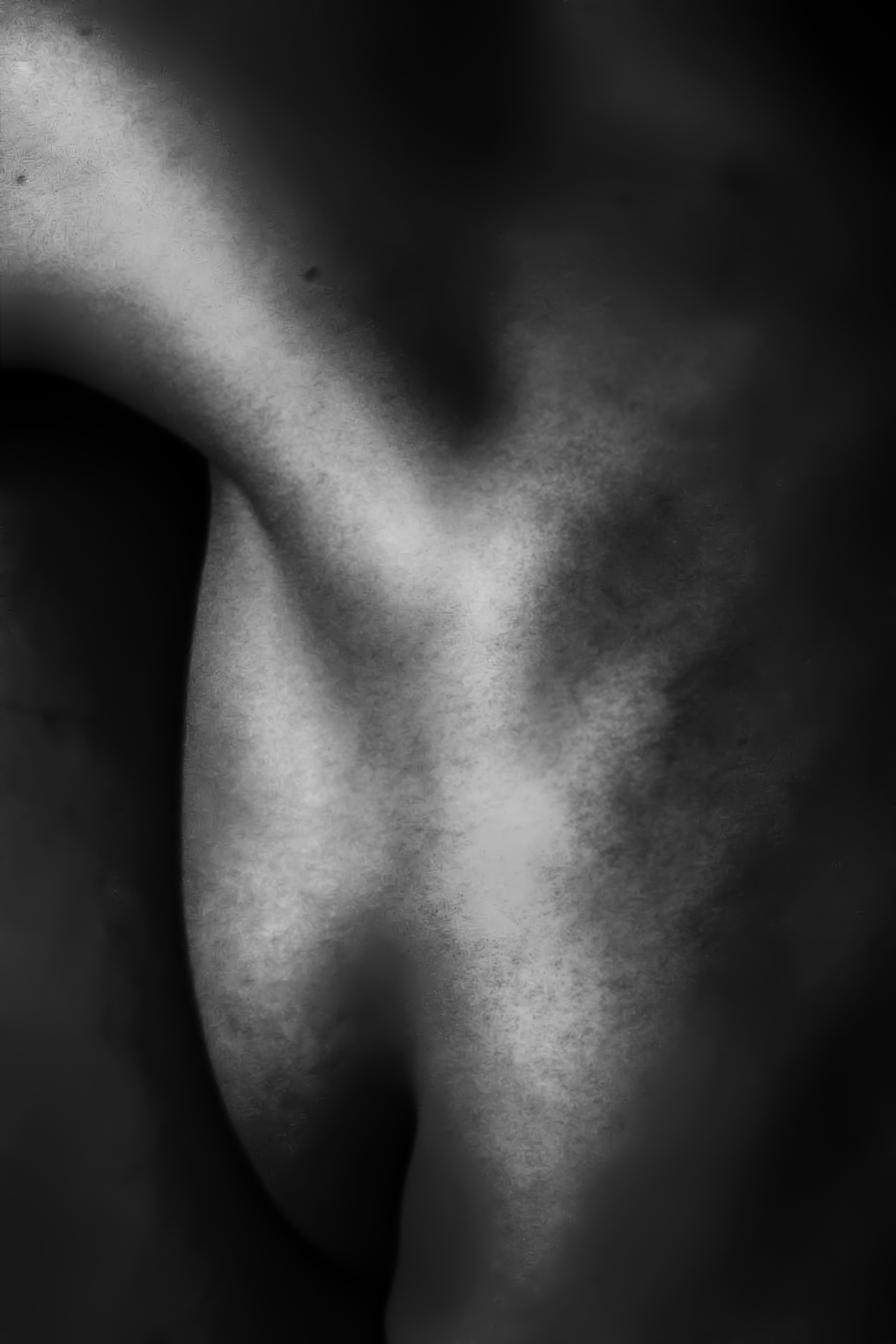 Close-up black and white photograph of a person's ear and neck area.