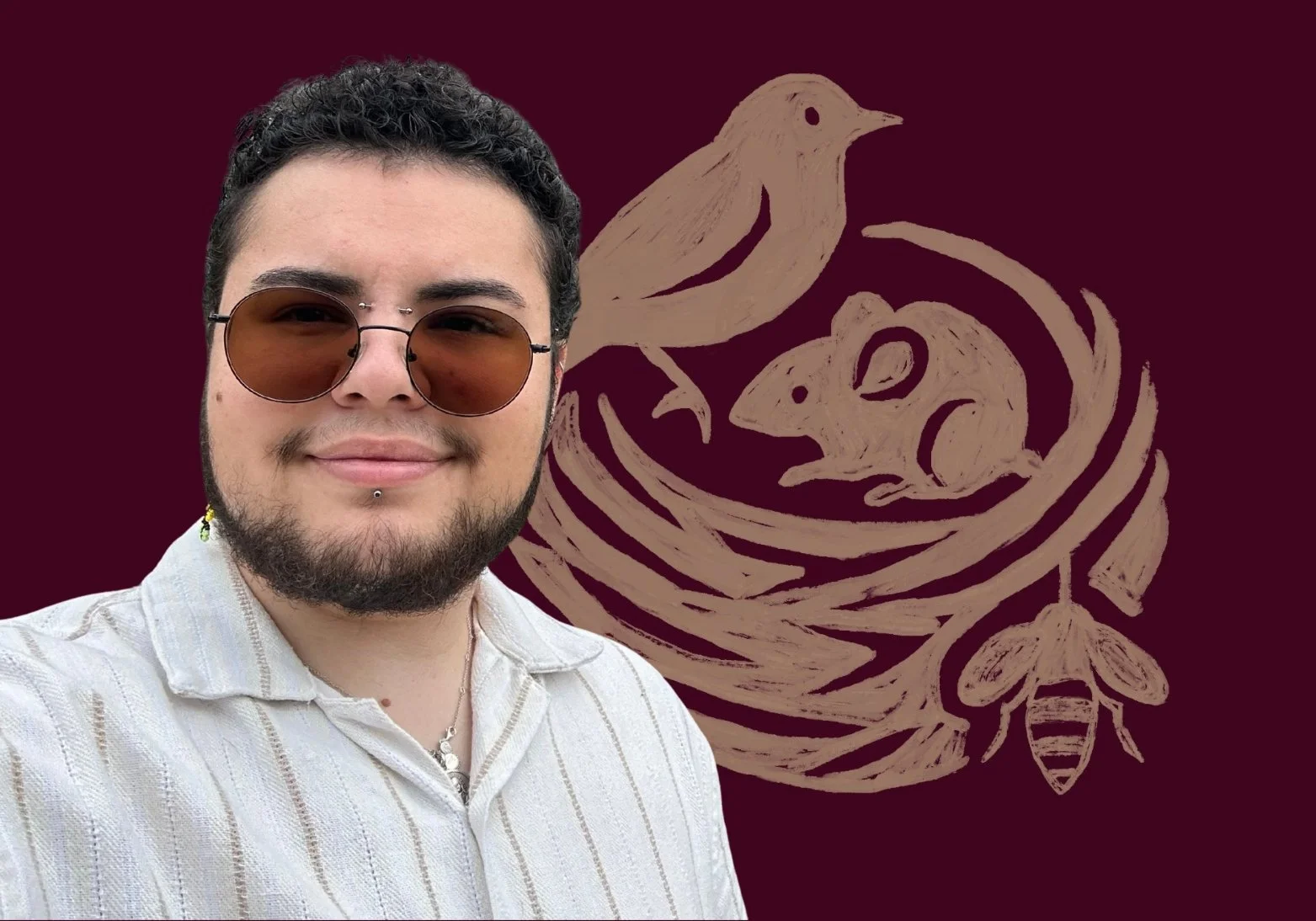 Portrait of Mia with dark curly hair, sunglasses, a beard, and piercings, smiling in front of a maroon background with a beige illustration of a bird, a mouse, and a bee in a nest.