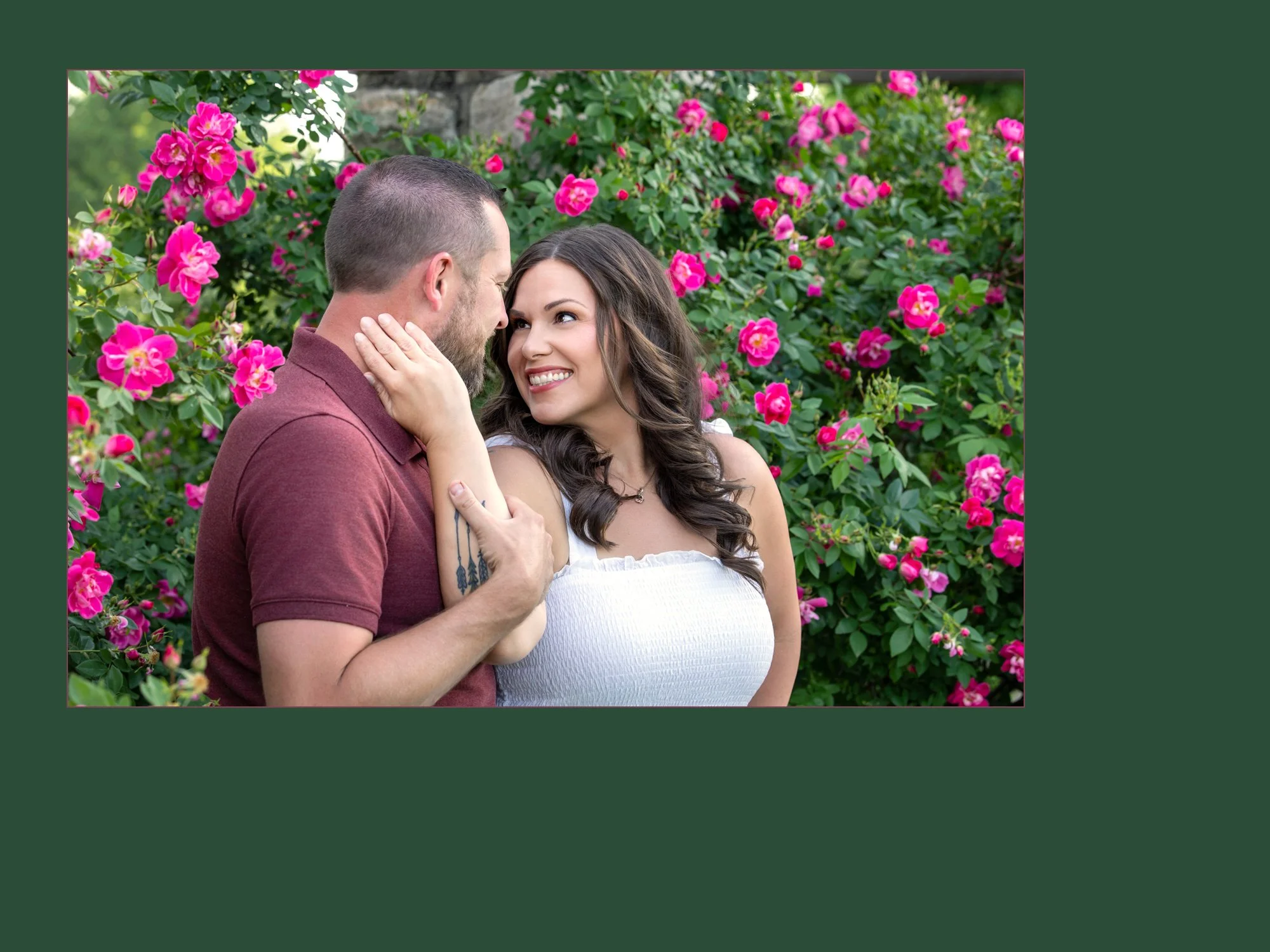 Kc engagement photography at Loose Park in the rose garden.  Couple is surrounded by bright pink roses.