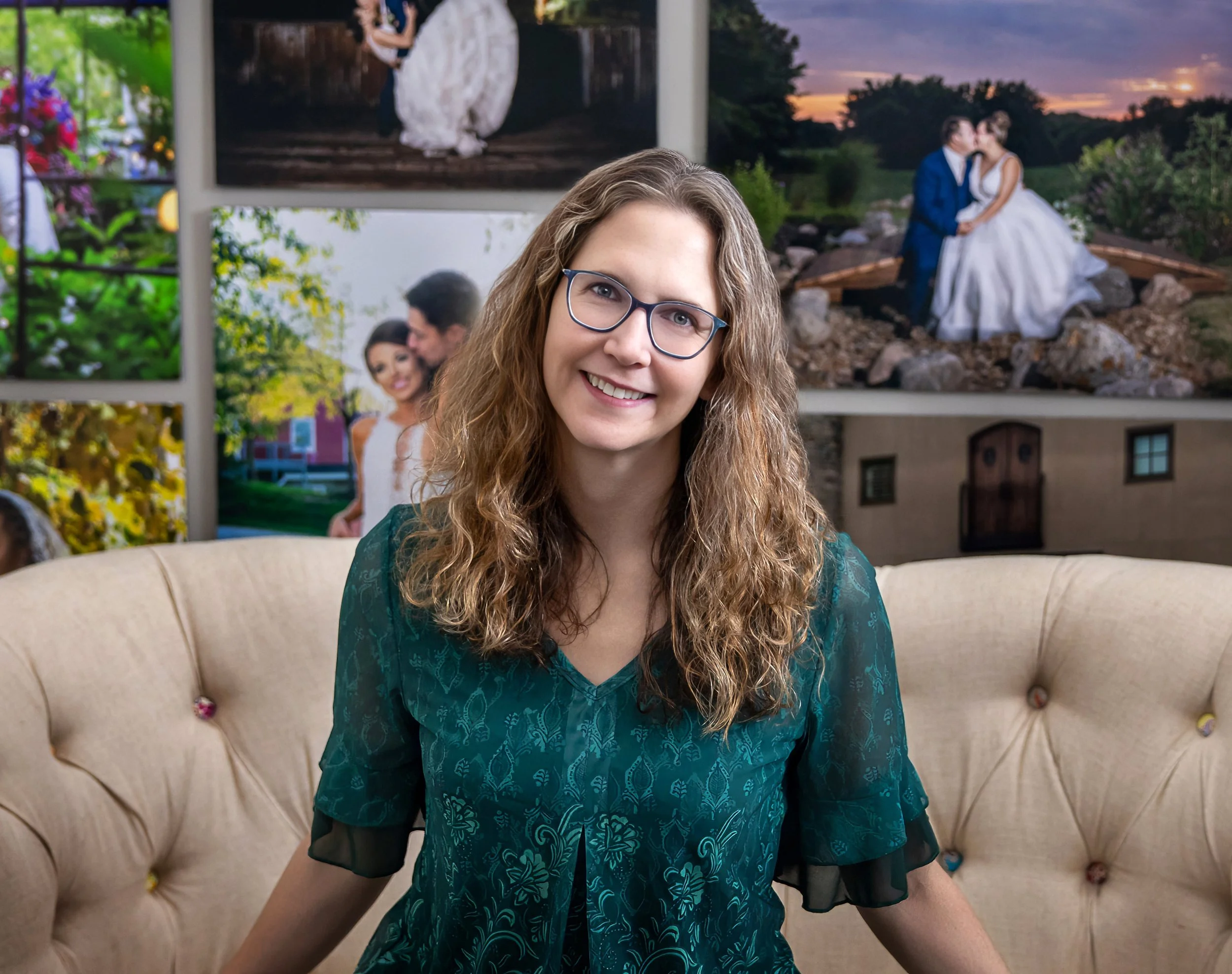 Angi, a wedding photographer in KC, dressed in green, sitting in front of a wall of wedding images.