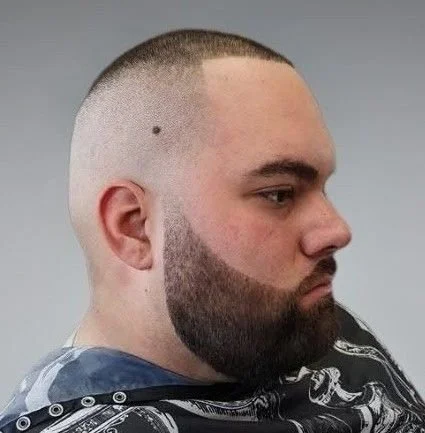 Profile of a man with a fade haircut and full beard, wearing a hoodie