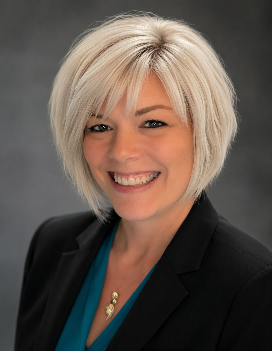 a person with blonde hair in a black blazer smiling