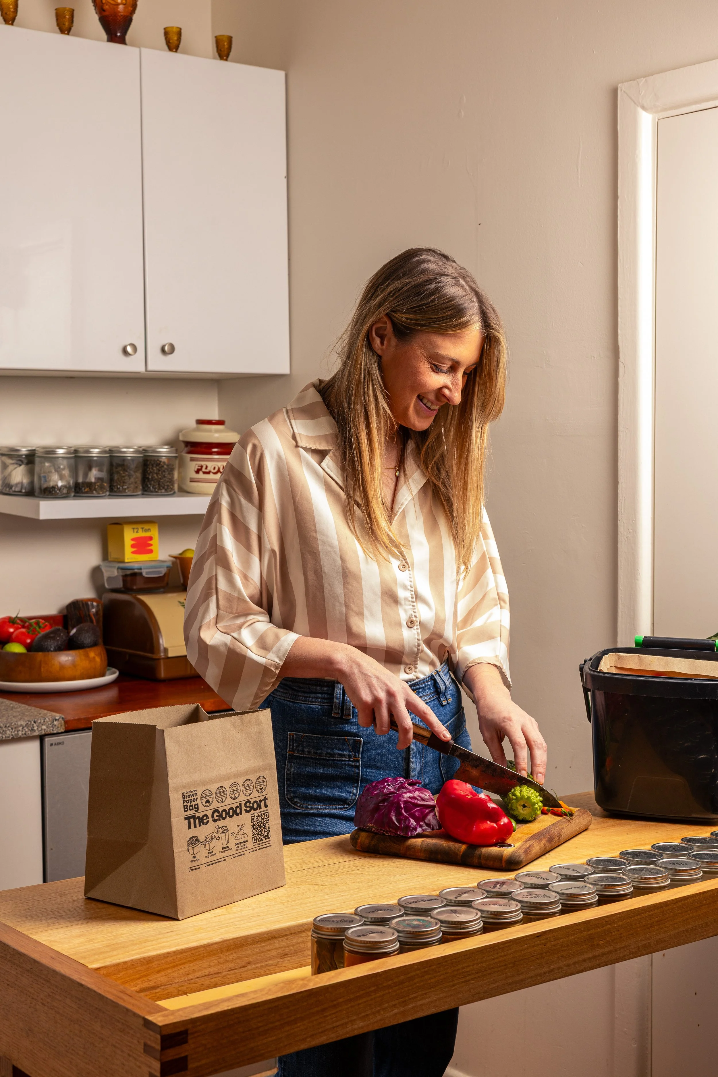 The Good Sort - Person cutting vegetables beside The Good Sort paper caddy liner in a home kitchen.