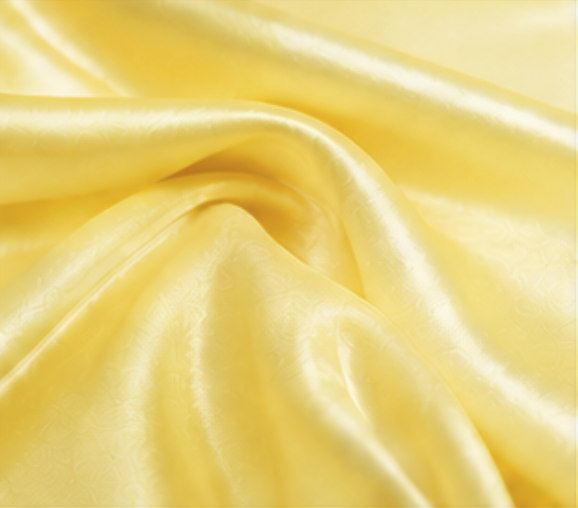 Close-up of silky, yellow satin fabric with smooth folds and sheen.