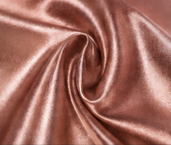 Close-up of shiny, pink satin fabric with a subtle floral pattern, gathered and twisted in the center.