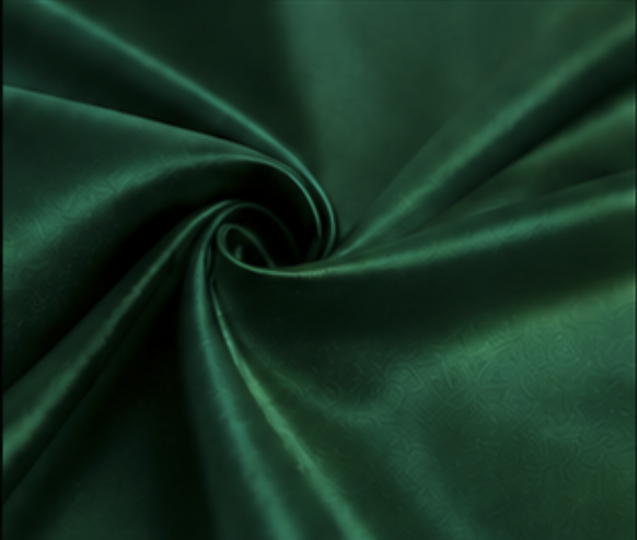 Close-up of green satin fabric twisted into a spiral.