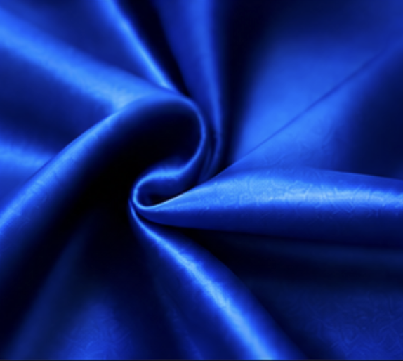 Close-up of shiny blue fabric twisted into a spiral.