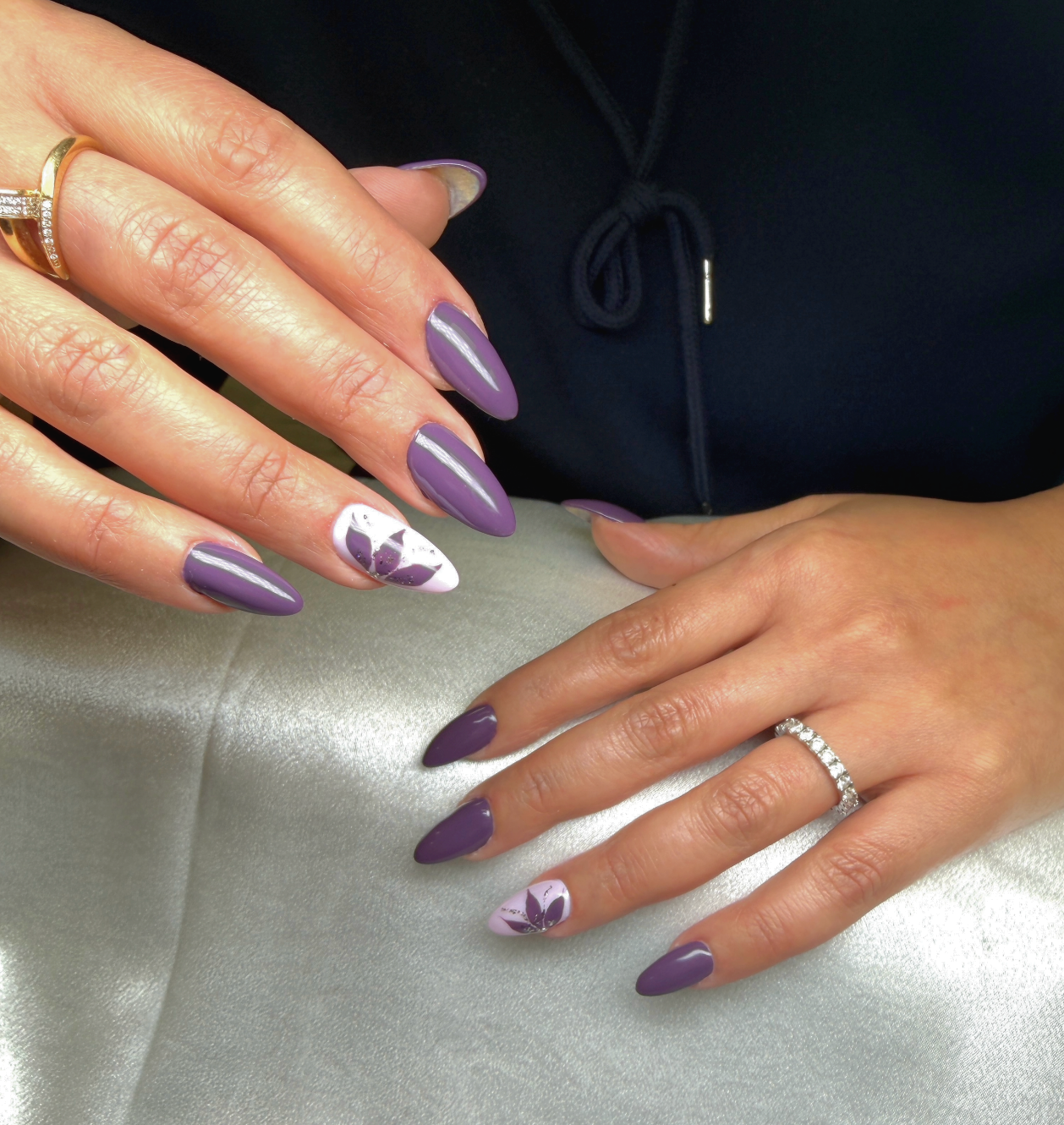 Close-up of a person's hands showing purple manicured nails.