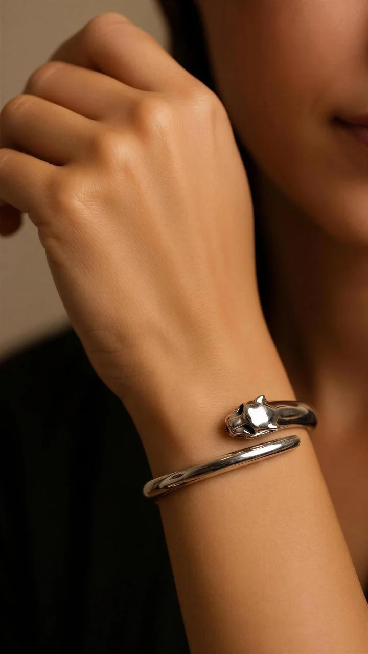 Close-up of a woman's wrist wearing a silver bracelet with a panther head design. Part of the woman's face is visible with a slight smile.