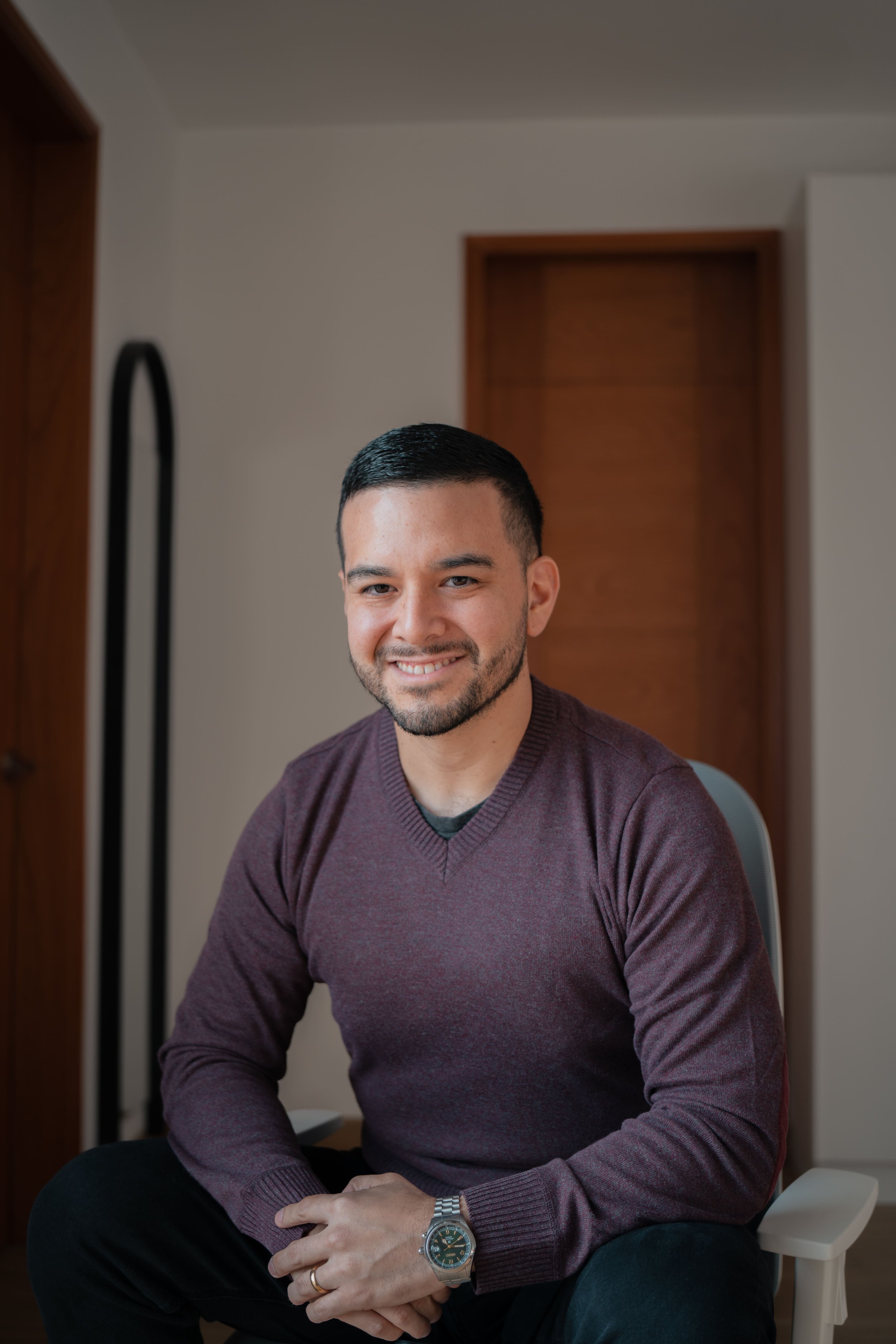 Retrato de Julio Diego Rodriguez, fotógrafo, sonriendo en un interior cálido.