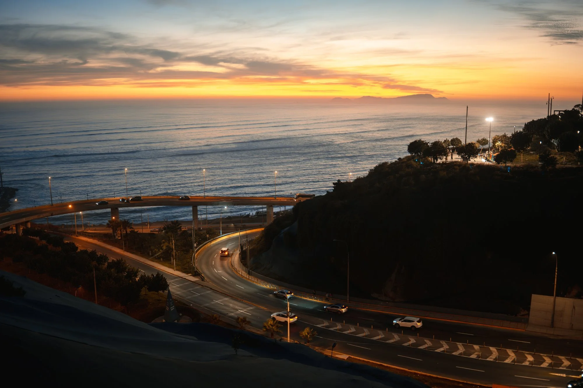 Larga exposición del tráfico en la Costa Verde al atardecer