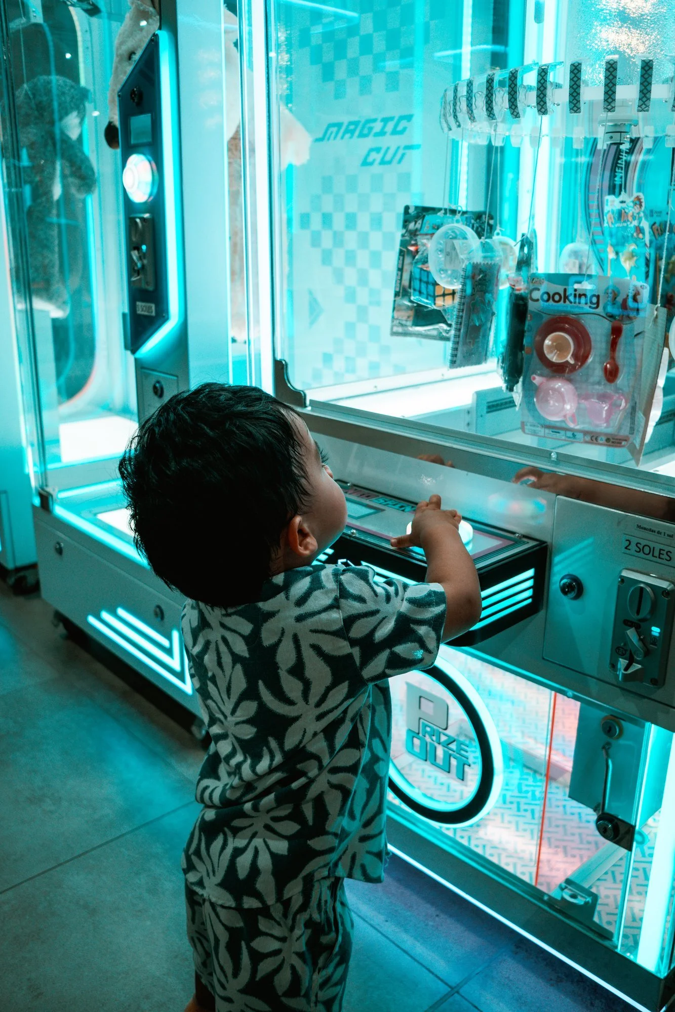 Niño mirando una máquina de peluches