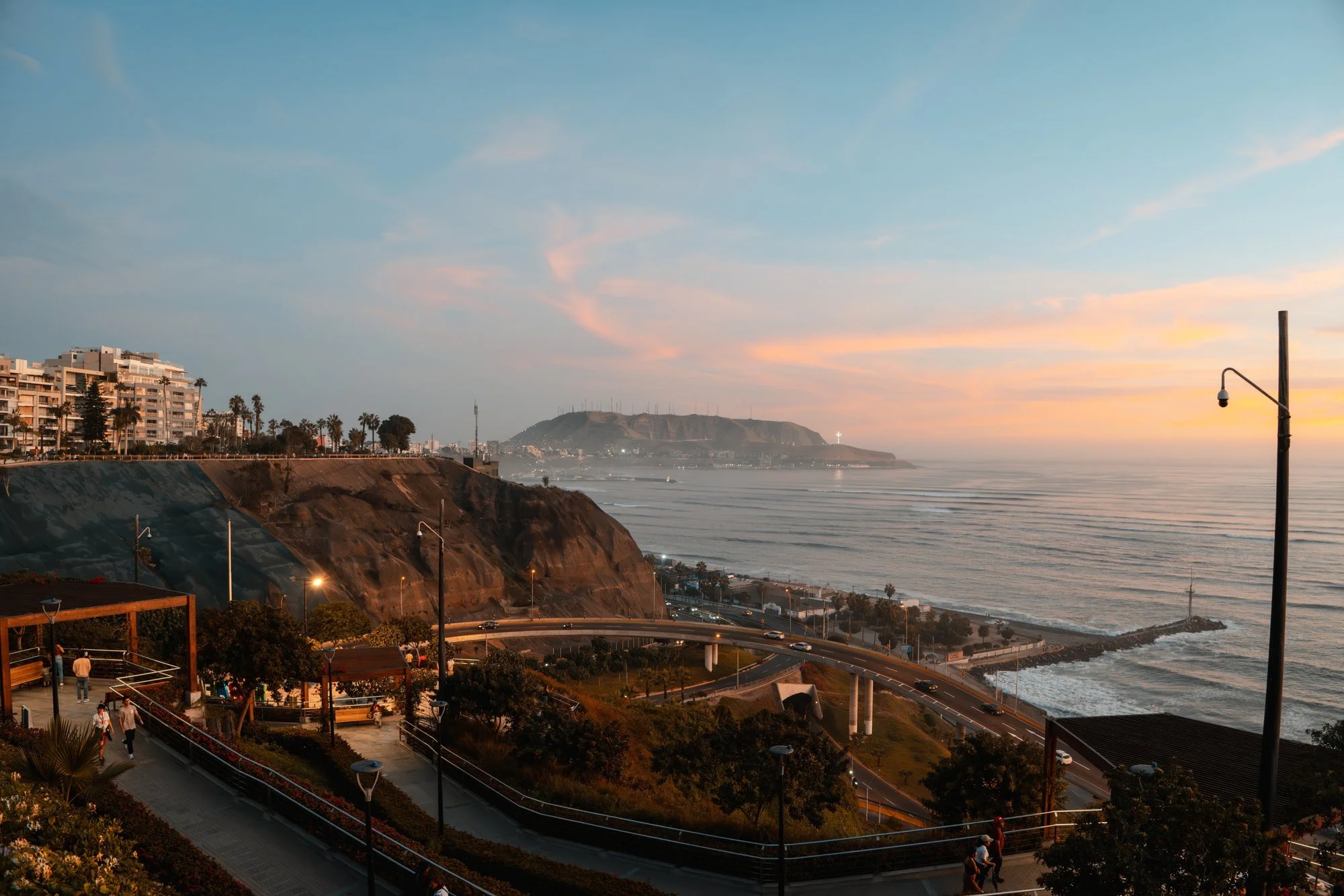 Vista del malecón y los acantilados con farola al atardecer