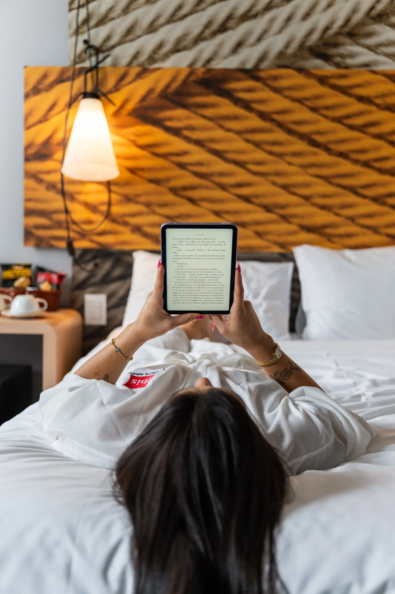 Huésped en la cama mirando una tablet