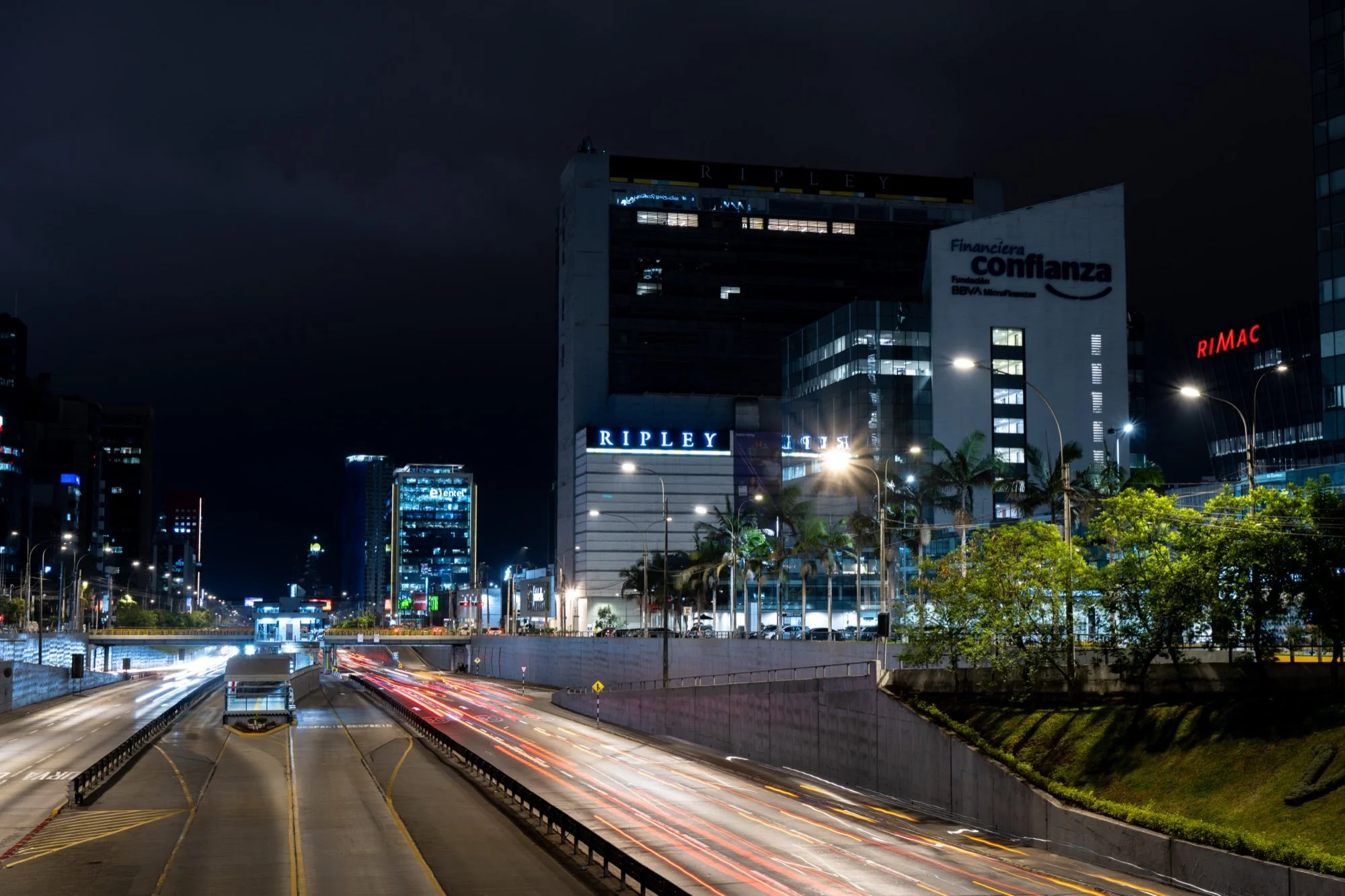 Vía Expresa de noche con estelas de luz frente a los edificios Ripley y RIMAC