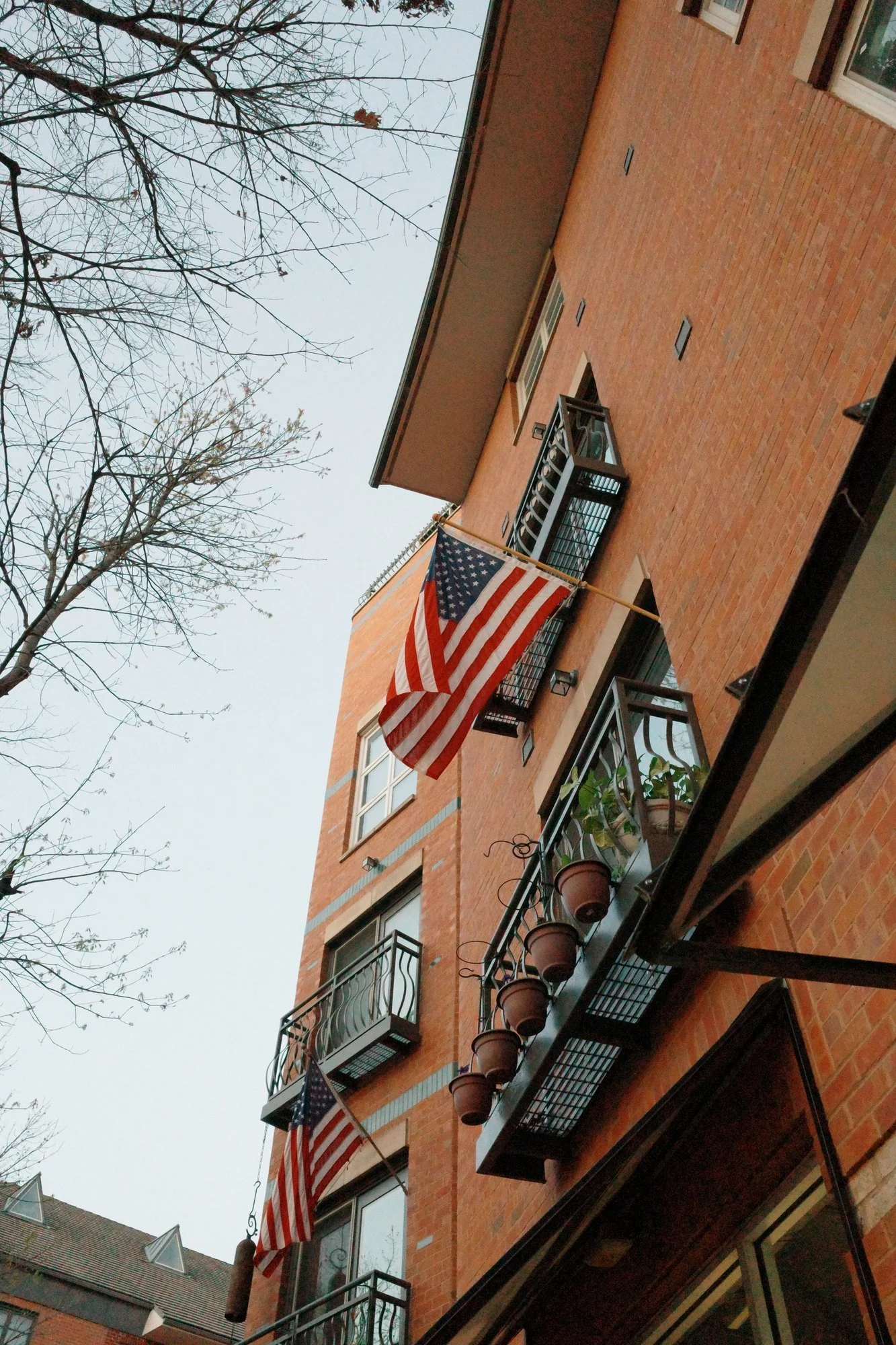 Banderas de Estados Unidos colgadas en los balcones de un edificio de ladrillo