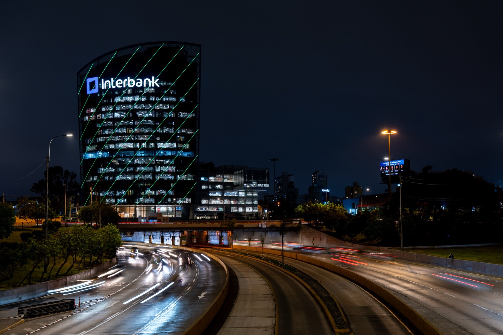 Torre Interbank iluminada sobre la Vía Expresa de Lima de noche