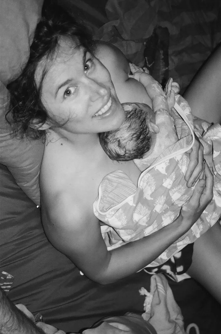 A woman holding a newborn baby in a hospital bed.