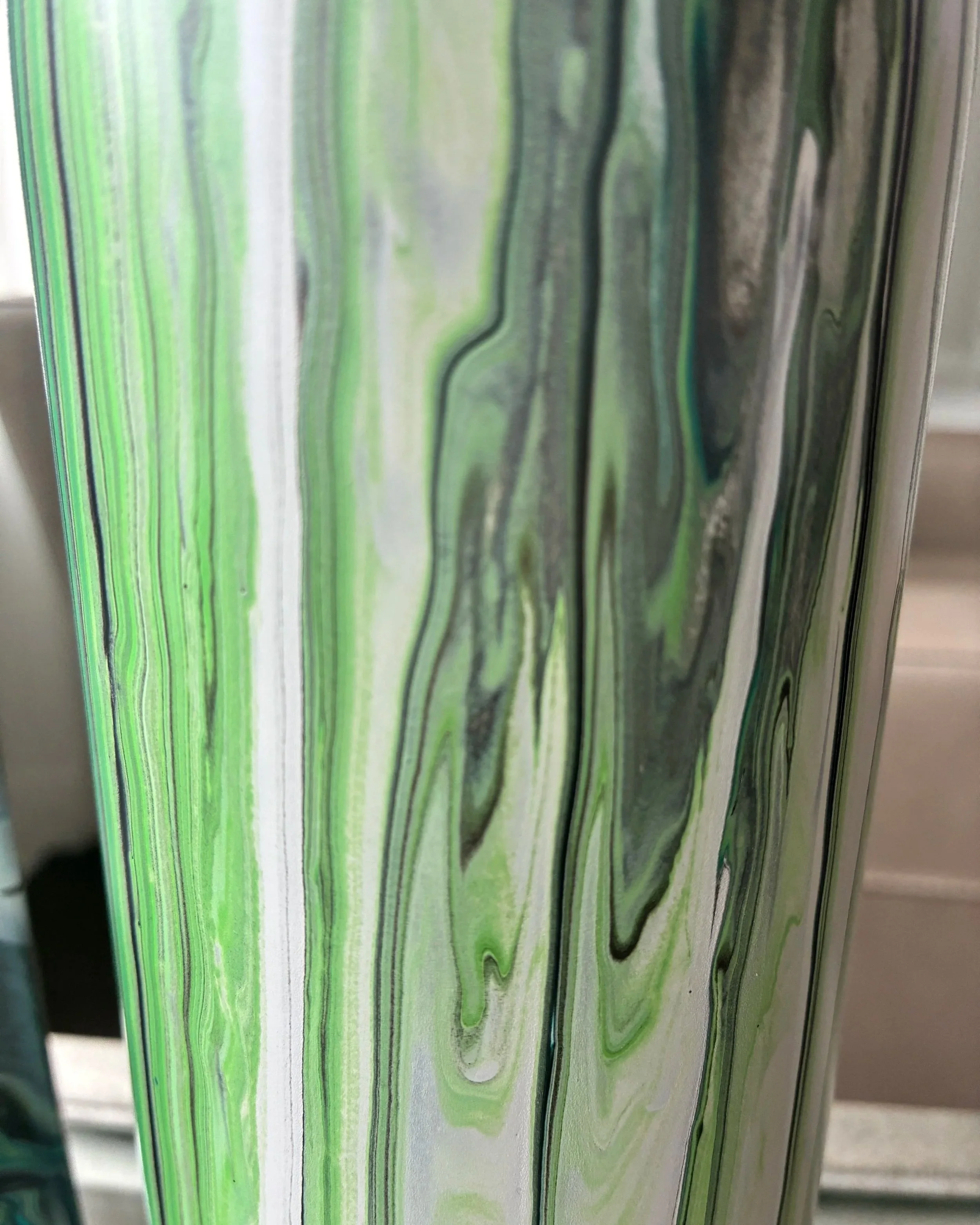 Close-up detail of emerald and ivory acrylic flow lines creating a fluid marble-inspired movement with soft organic texture