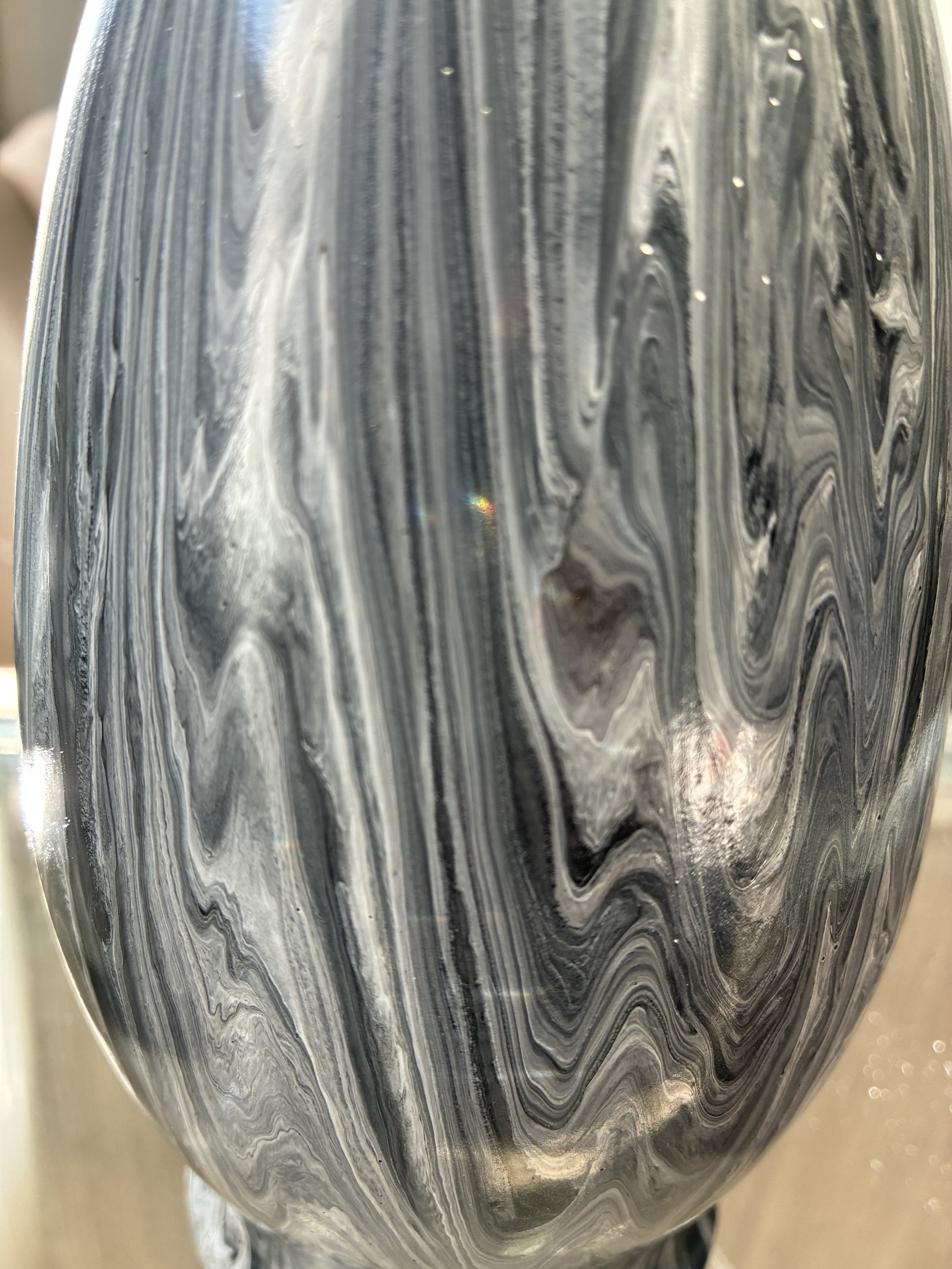 Close-up detail of Black Veil, revealing layered currents of black, charcoal, silver, and soft white. The flowing veining creates depth and movement, echoing the beauty of polished natural stone.