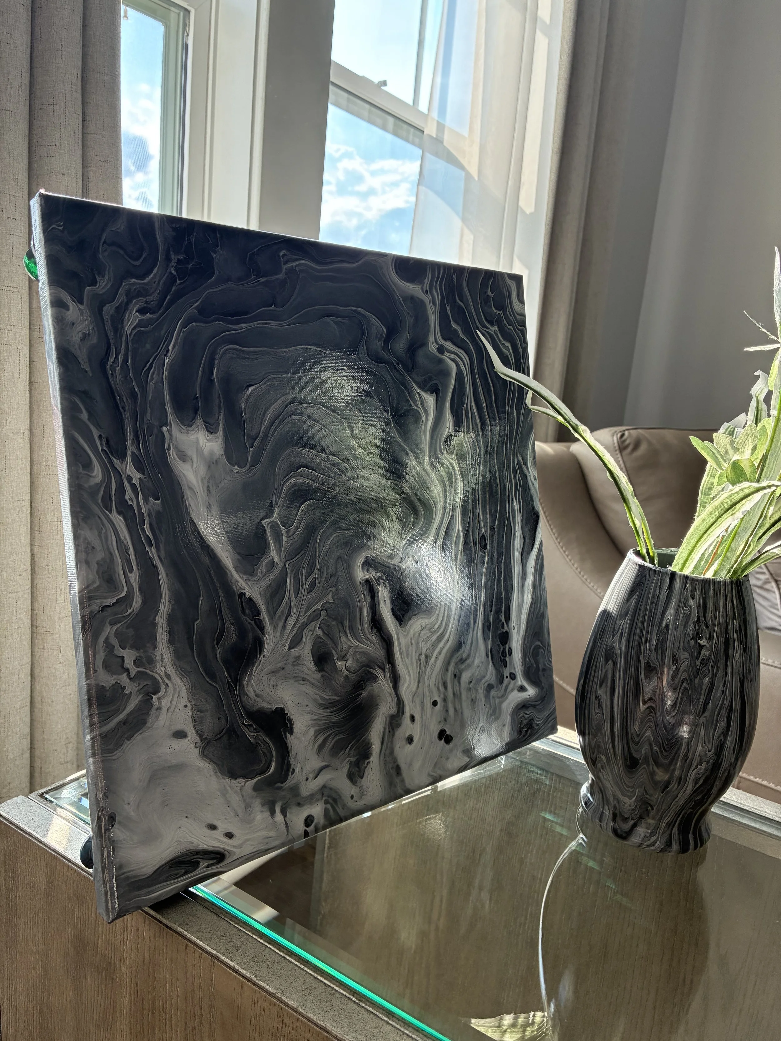 Phantom Vein canvas paired with the Black Veil vase from the Obsidian Vein Collection. Flowing layers of black, white, and smoky gray create a dramatic composition inspired by natural stone formations and shifting shadows.