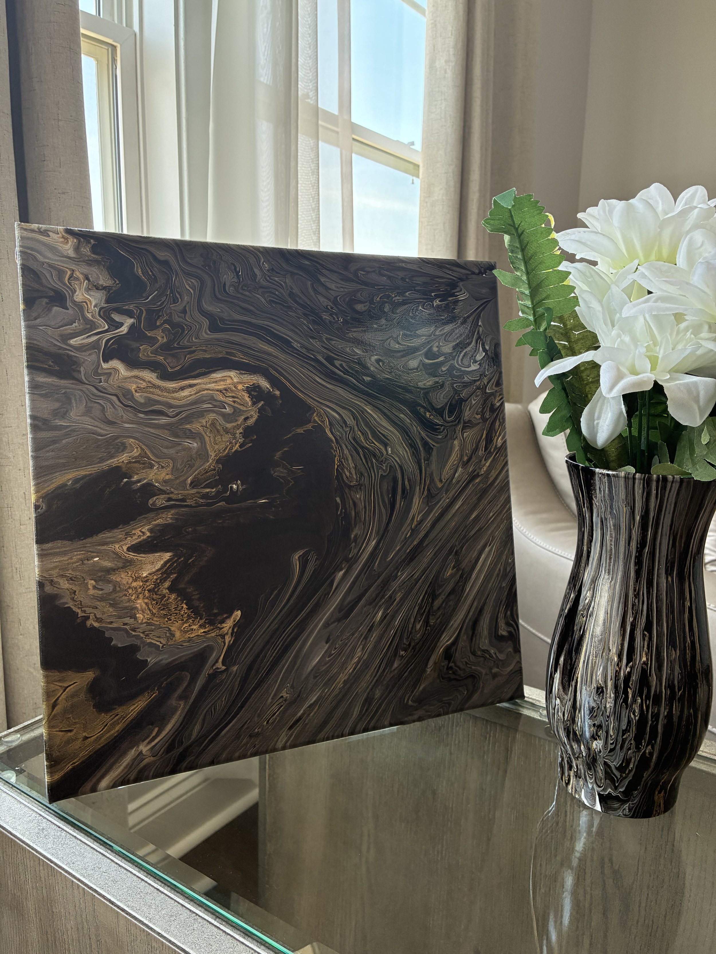 A dramatic handcrafted canvas and vase pairing from the Obsidian Vein Collection. Rich layers of black, charcoal, and bronze create a sense of movement, depth, and modern luxury inspired by the beauty of natural stone