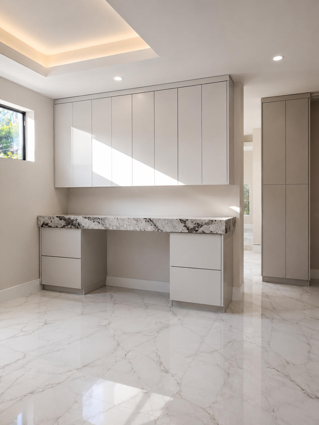 Modern minimalist kitchen with white cabinets, a marble countertop, and marble flooring, natural light coming through a small window.