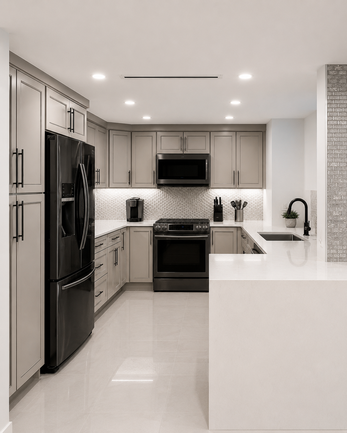 Modern kitchen with gray cabinets, black appliances, white countertops, and a textured backsplash, featuring a sink with a black faucet and a small plant.