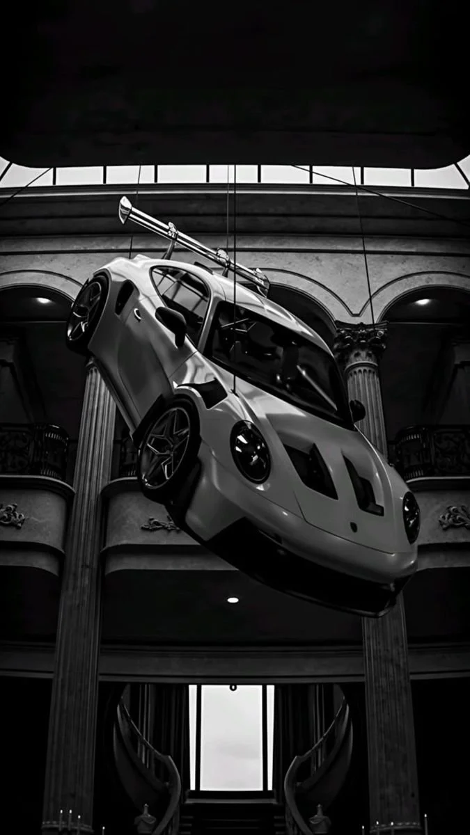 A race car with a parachute attached, displayed upside down in a grand hall with tall columns and ornate details.