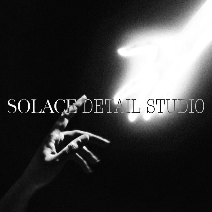 Black and white photo of a hand reaching towards a bright light source in the upper right corner, with the text 'SOLACE DETAIL STUDIO' overlaid.