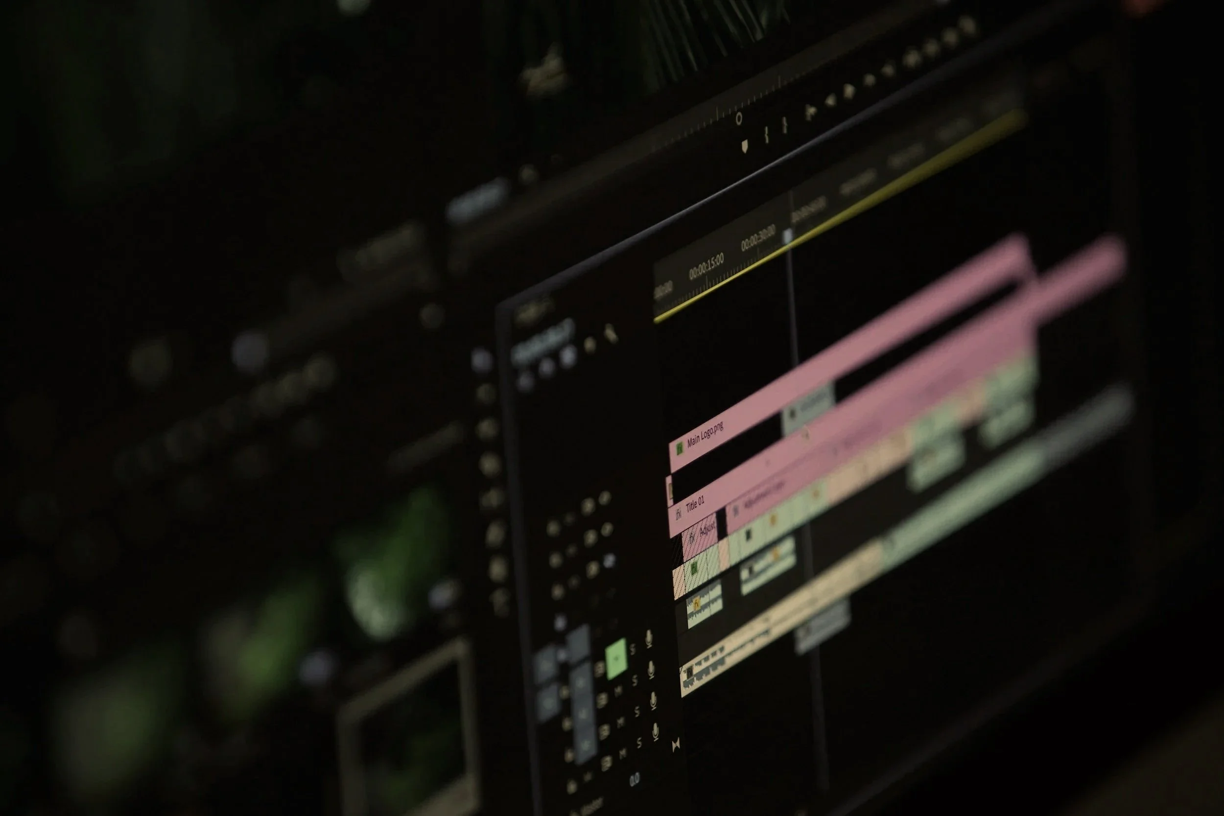 A dark computer screen displaying editing software with multiple timeline tracks and colorful clips.