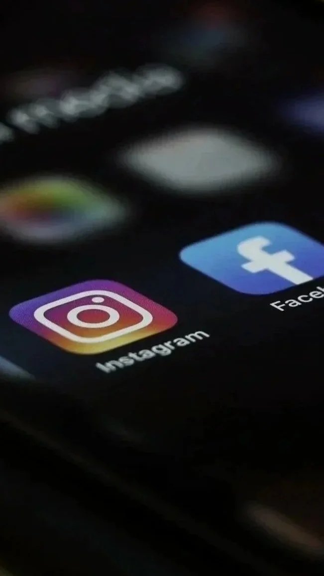 Close-up of a smartphone screen showing the Instagram and Facebook app icons. (Represents social platforms of any kind)