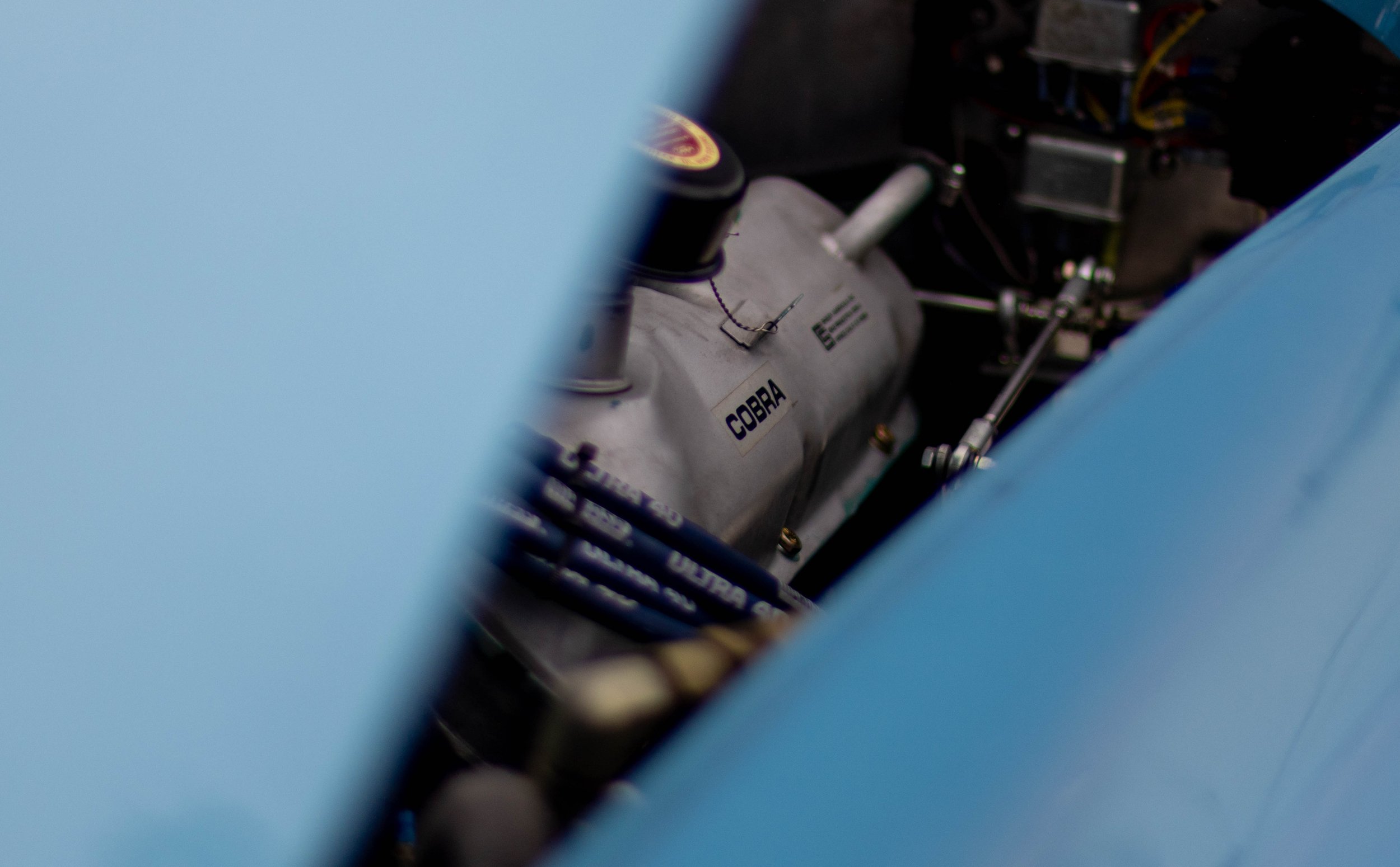 Close-up of a rocket engine with the label 'COBRA' on it, viewed through a narrow opening with bright blue edges.