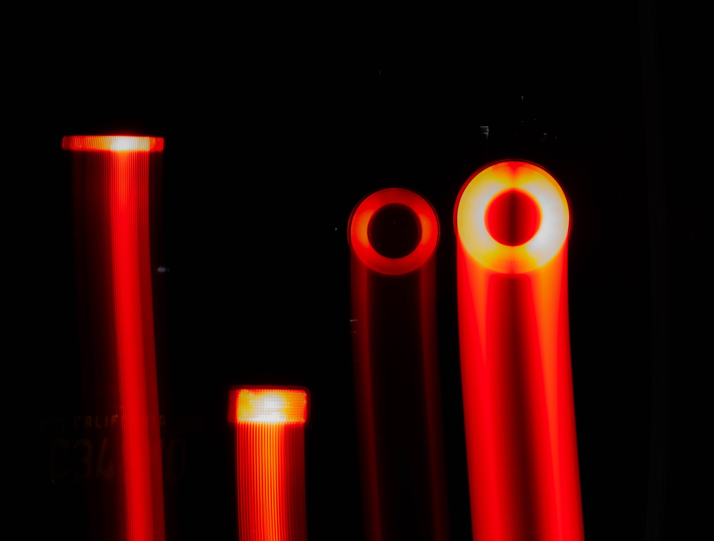 Close-up of car brake lights glowing red in a dark setting.