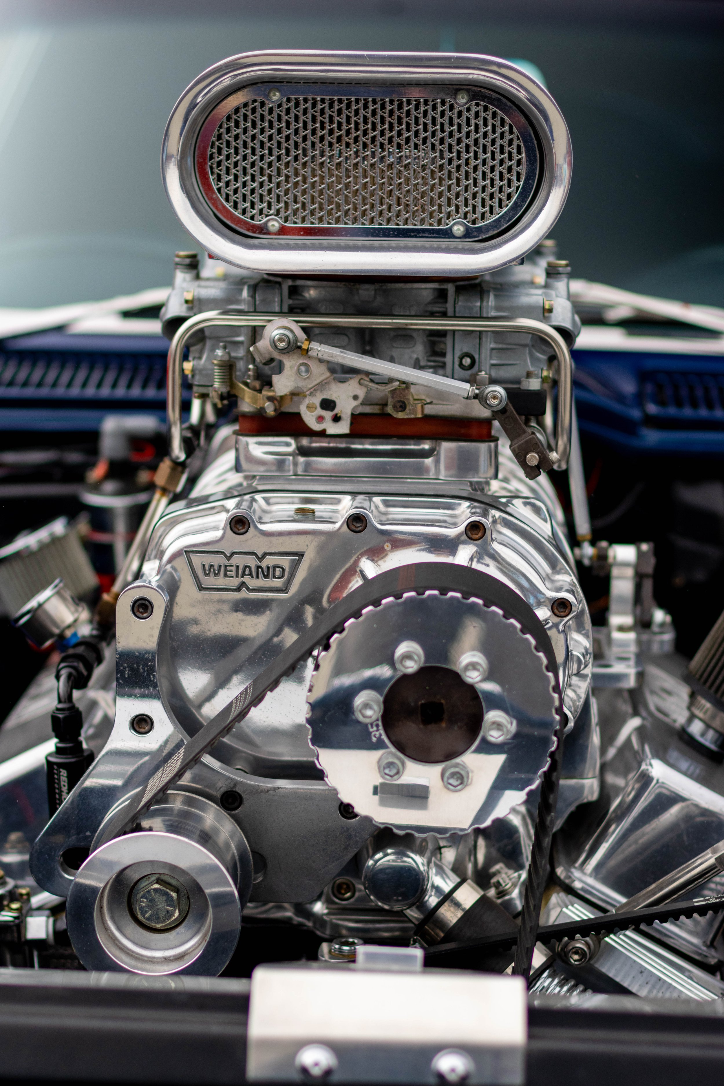 Close-up view of a mechanical engine with visible metal gears, belts, and components.
