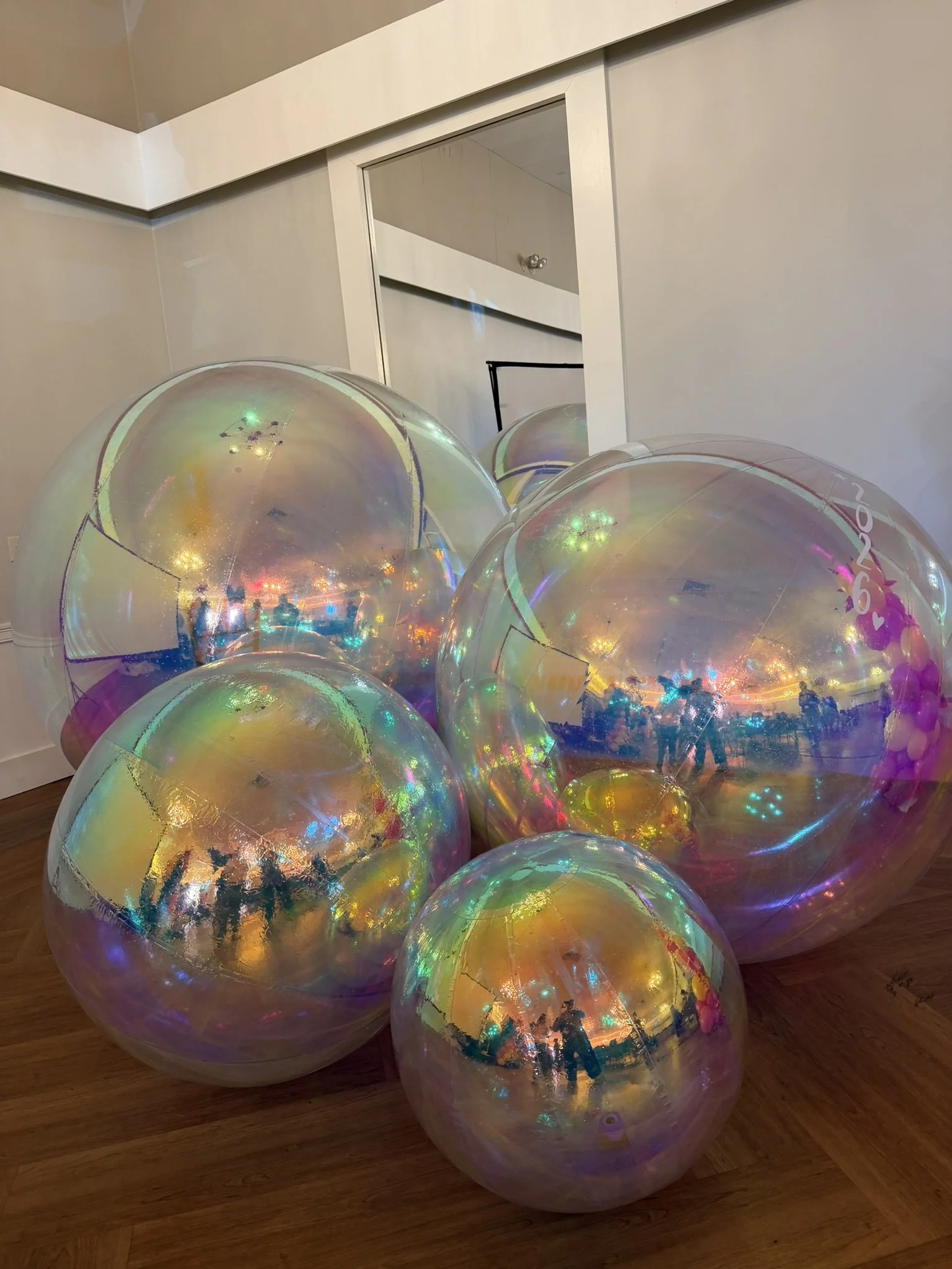 Large transparent iridescent balloons with LED lights used for stylish event decor in Boston.