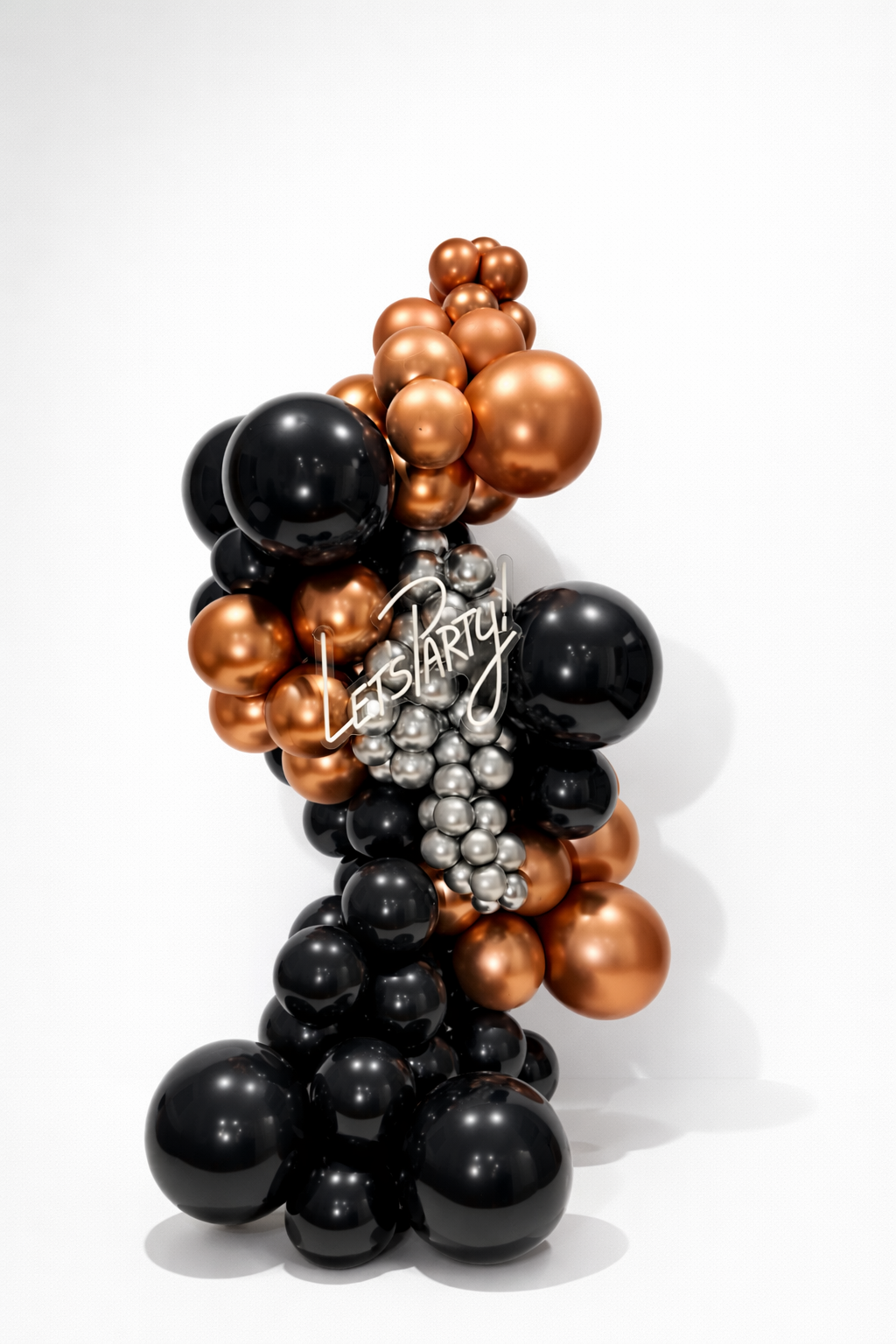 Balloon arrangement with black, copper, and silver balloons, featuring a neon sign that reads "Let’s party!"