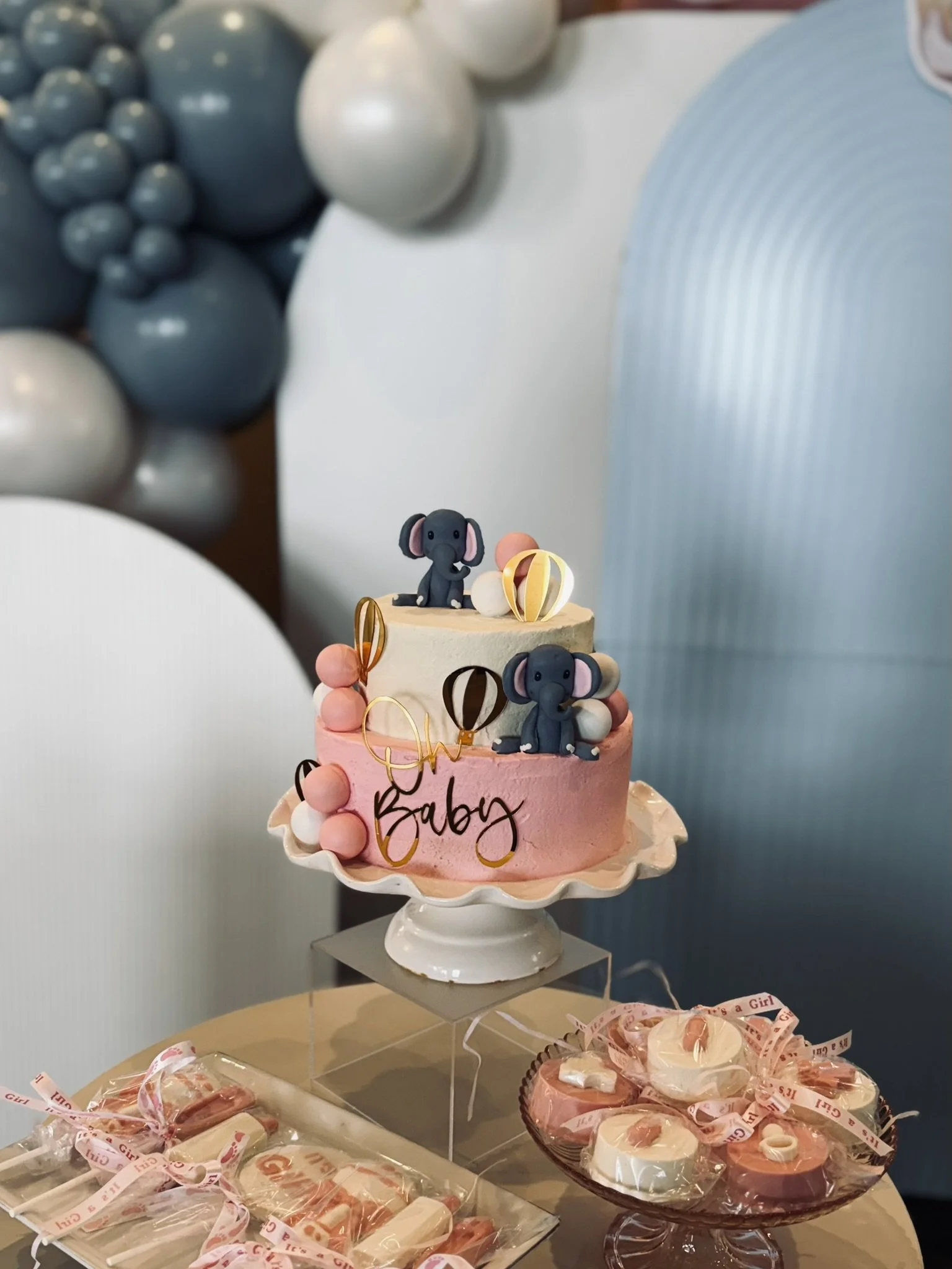 Elephant-themed baby shower cake table with pastel balloon decor, pink treats, and custom party details in Boston.