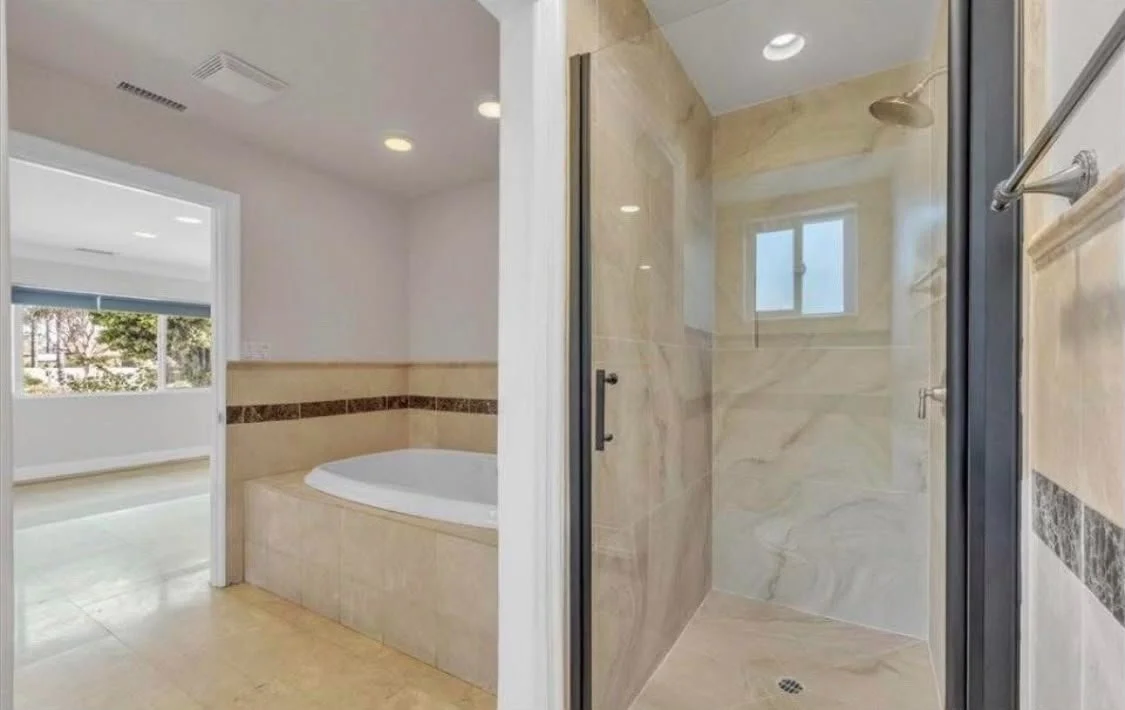 Bathroom with a bathtub and a separate glass-enclosed shower.