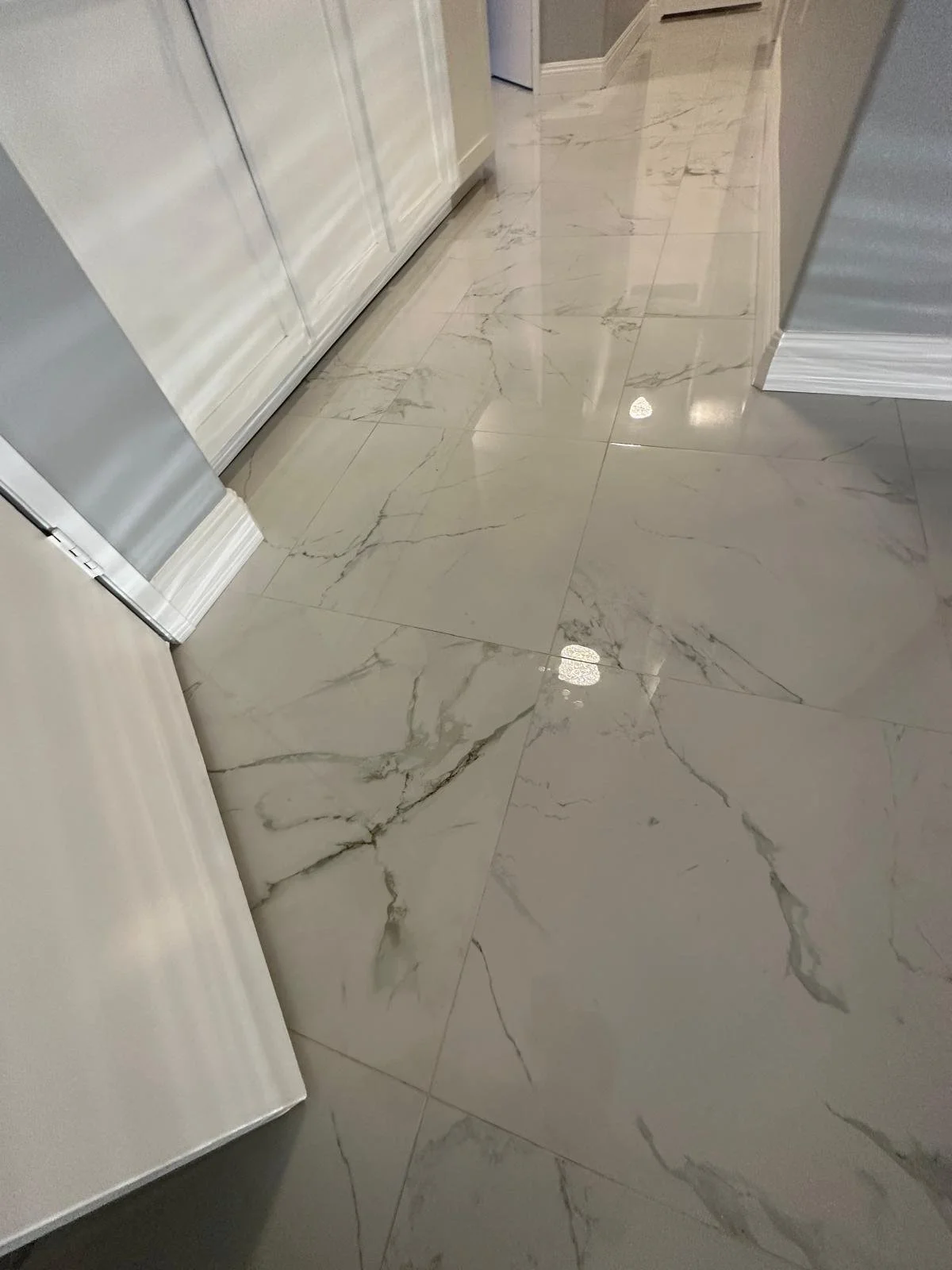 Close-up of a polished marble flooring with gray and white veining in a modern interior space.