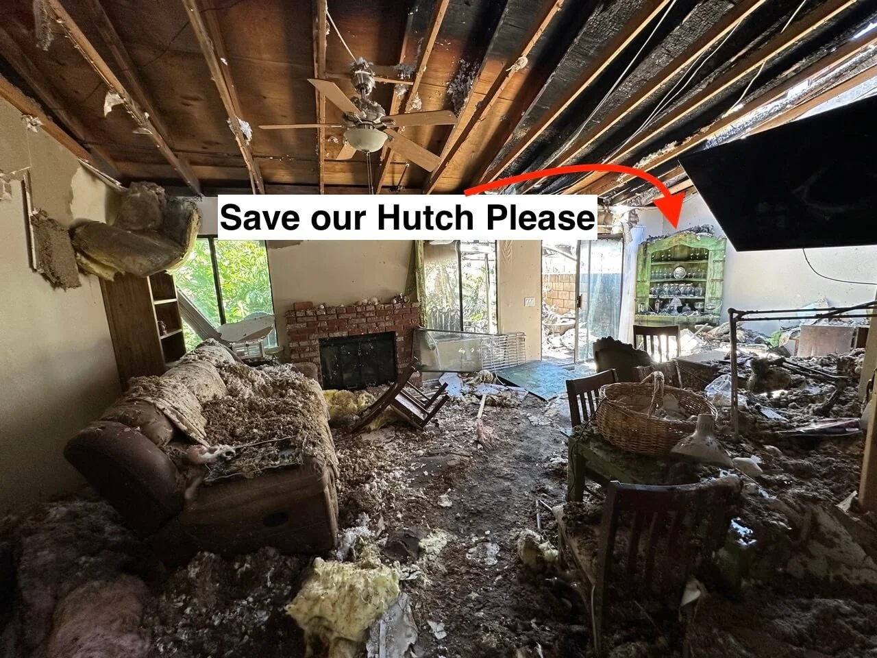 Living room in total disaster, with debris, damaged furniture, and a burned ceiling, indicating recent fire damage. The scene is chaotic with smoke residue and burned materials, and a caption says 'Save our Hutch Please' with an arrow pointing toward