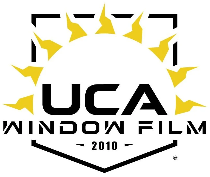 Logo for UCA Window Film, established in 2010, featuring a black shield outline, yellow sun rays surrounding the top, and bold black text.