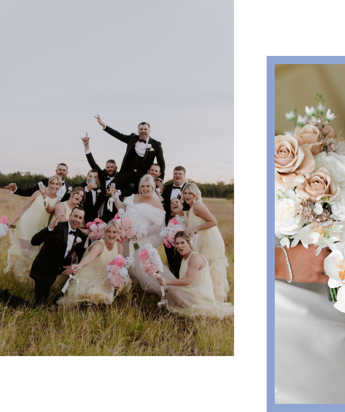 A wedding party in formal attire celebrating outdoors in a field, with the groom being lifted by friends, holding bouquets, and all smiling.