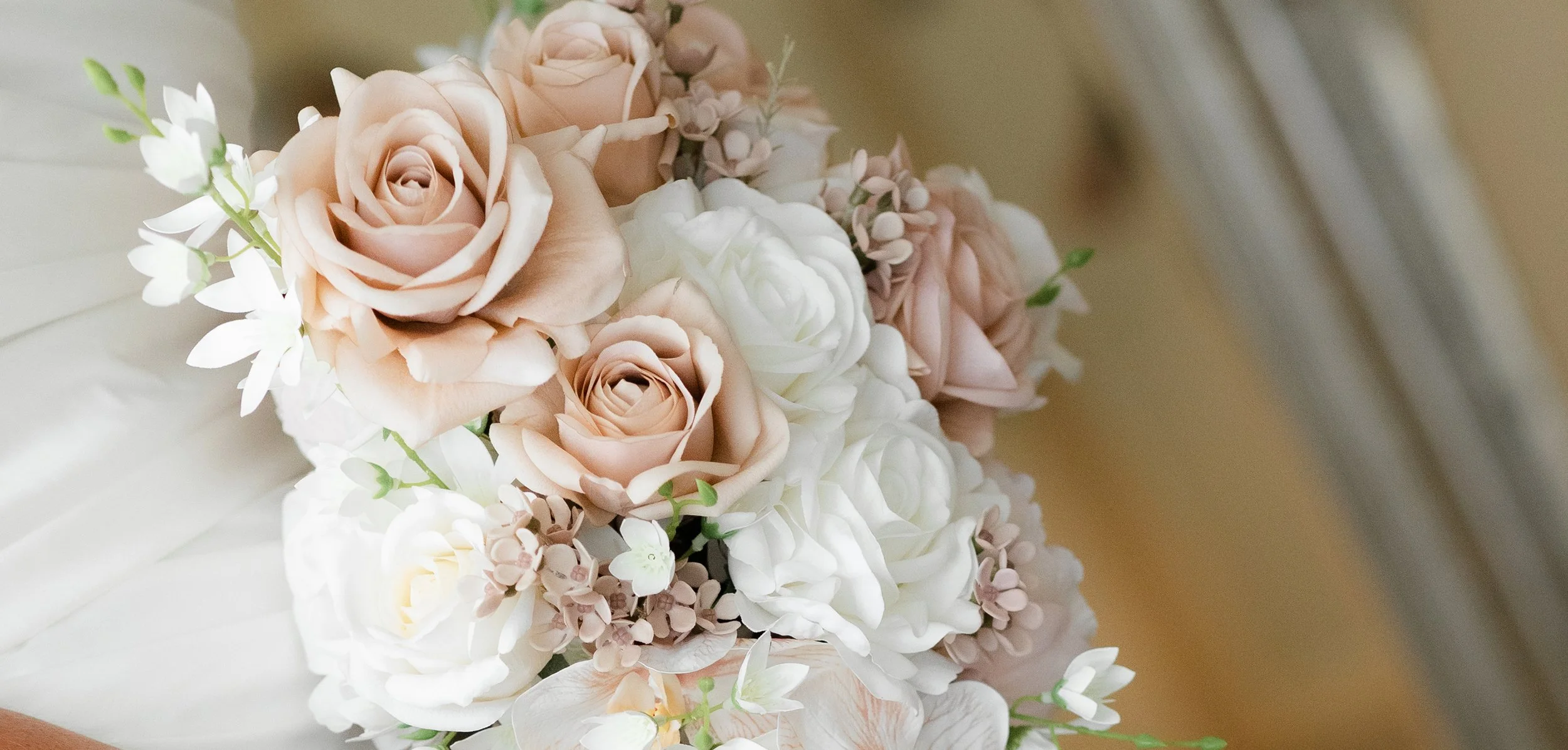 A bouquet of pastel-colored roses, white hydrangeas, and small white and pink flowers.