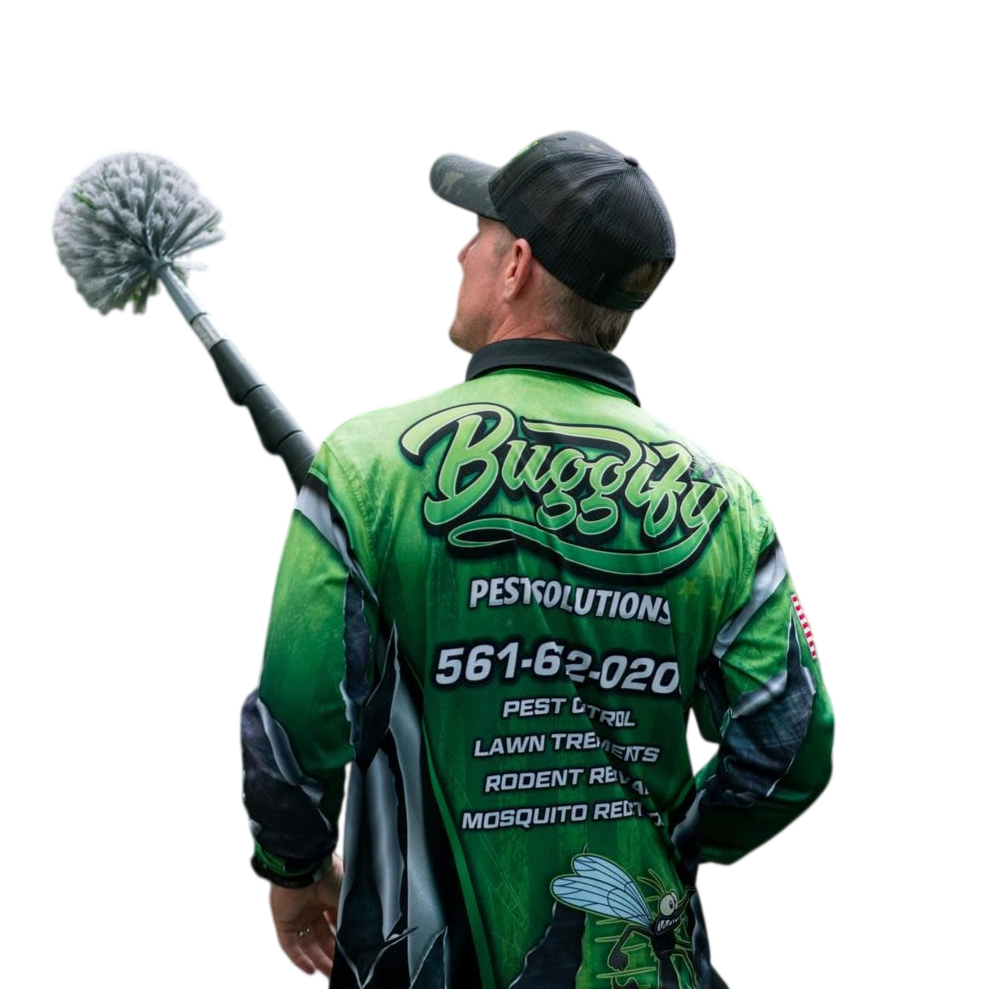 A pest control worker holding a duster or pest control tool, wearing a green and black uniform with the words "Buggy" and "Pestolutions" printed on the back, including a phone number and services such as pest control, lawn treatments, rodent removal, and mosquito removal.