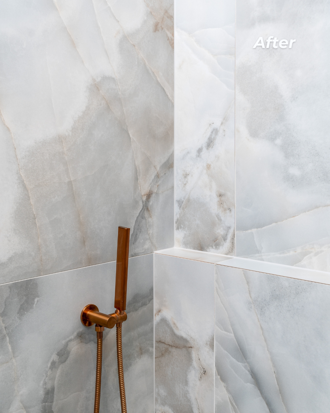 Bathroom shower with large gray marble tiles and a copper hand shower mounted on the wall. The image has an 'After' label in the top right corner.