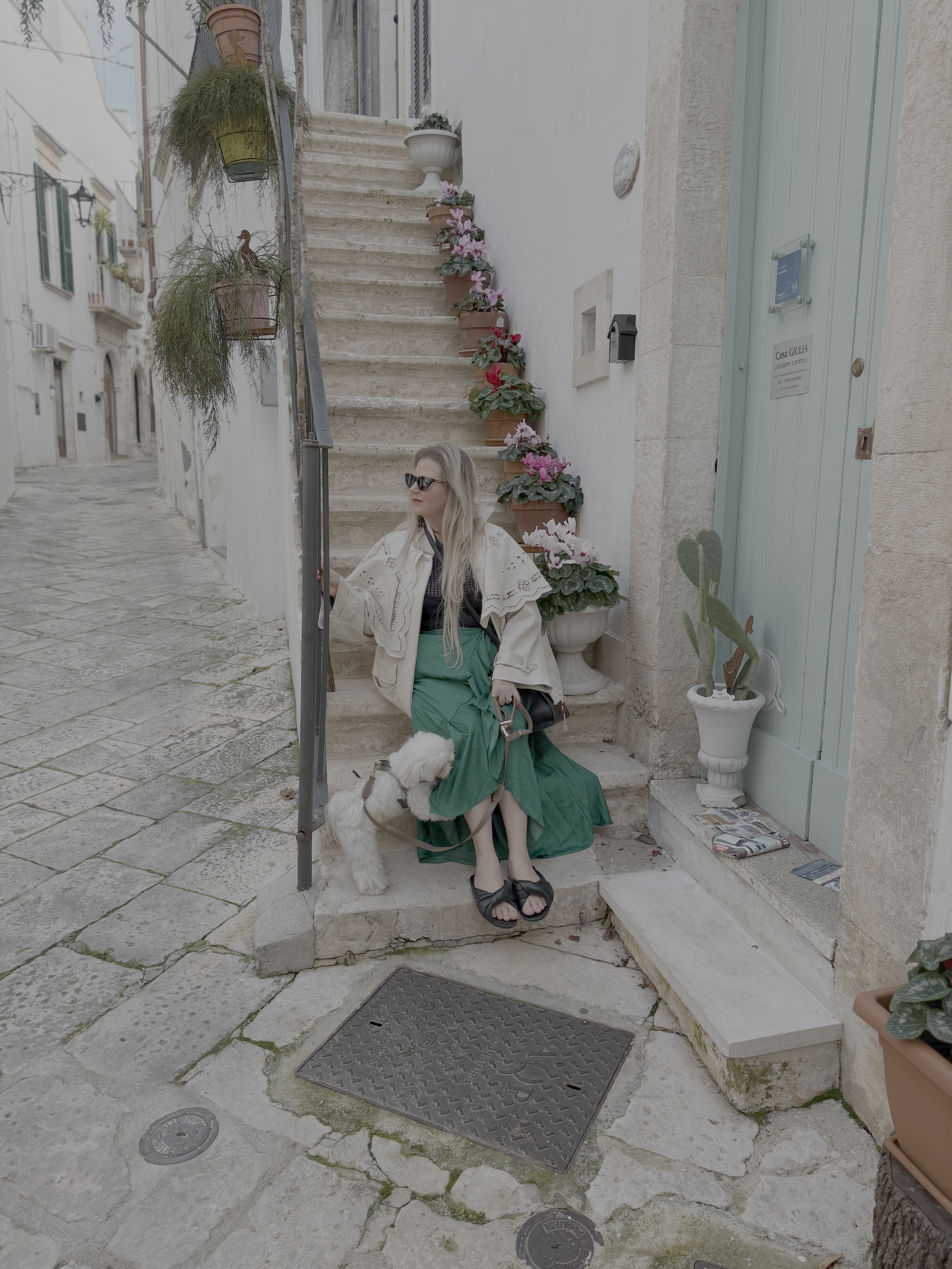 woman sitting on stone steps in italy with her dog