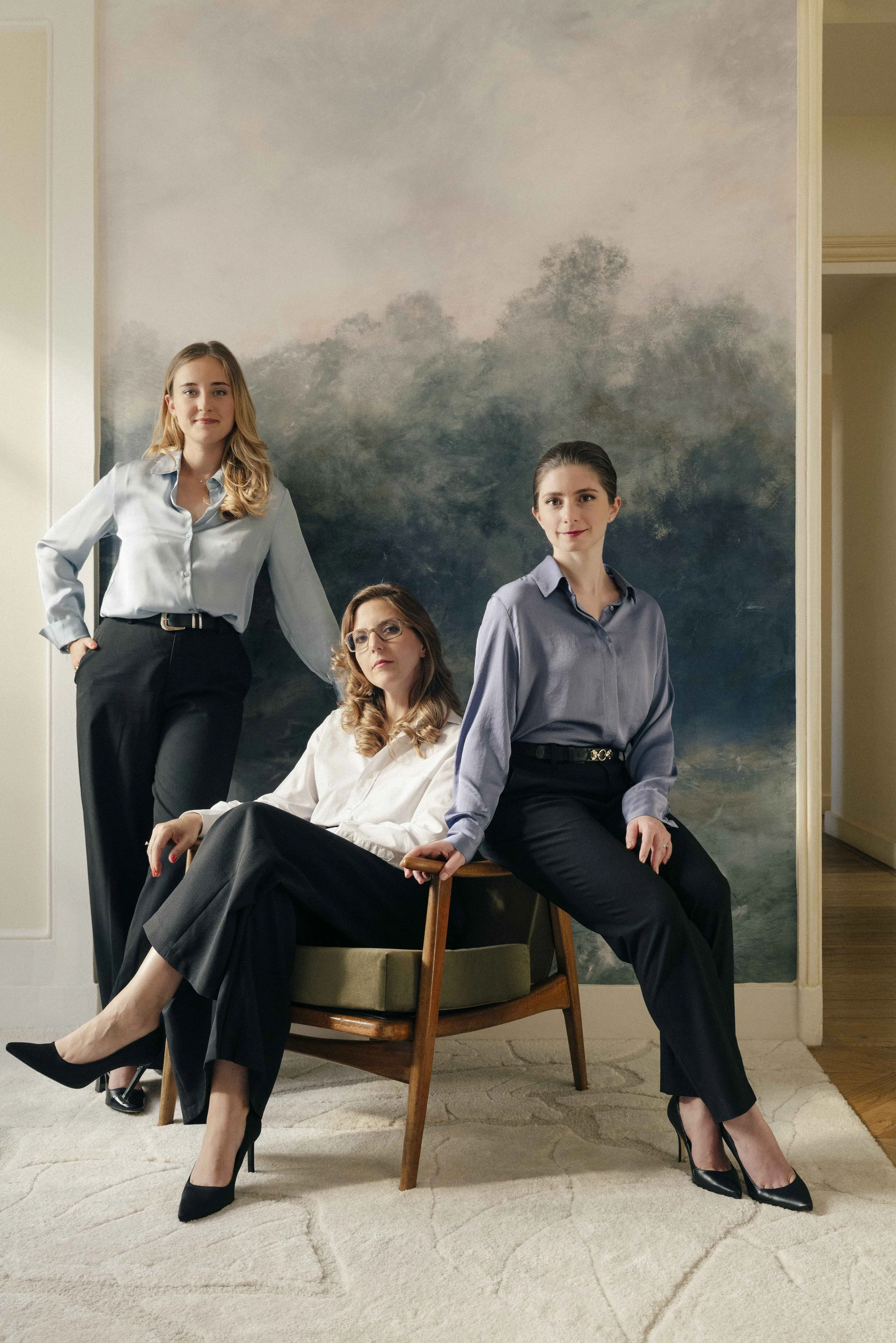 quatre femmes d'affaires en tenue professionnelle posent dans une pièce avec un fond de paysage nuageux dans un style peint.