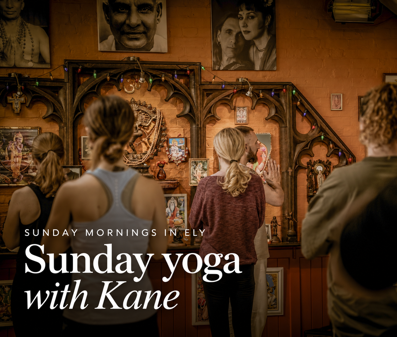 People participating in a Sunday yoga session at a wellness center, with spiritual artwork and photographs on the wall.